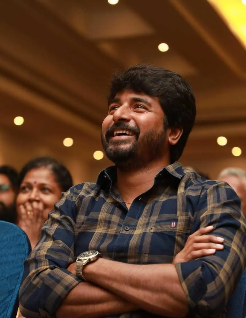 Sivakarthikeyan Smiling with Arms Crossed At Event Wallpaper
