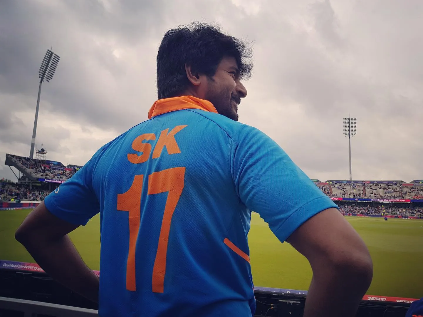 Sivakarthikeyan Standing in Stadium with Indian Jersey Image