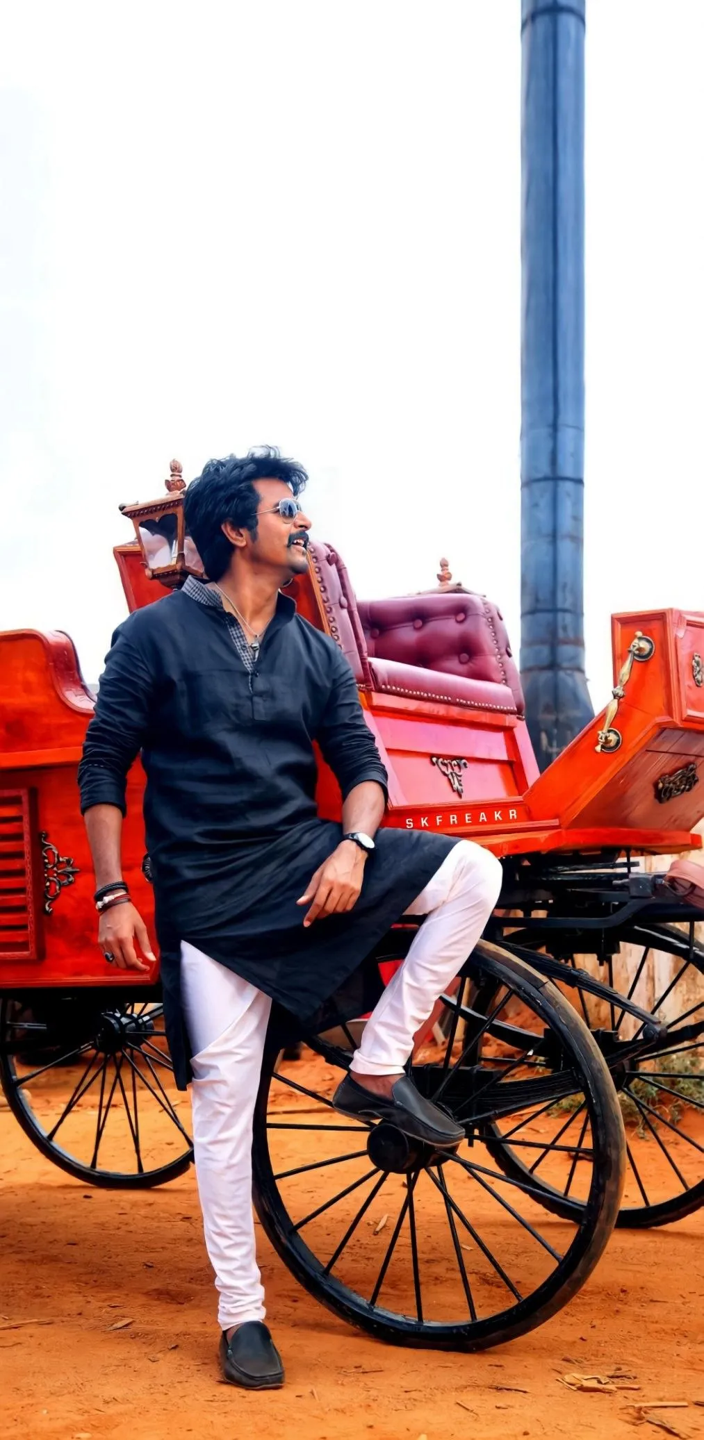 Sivakarthikeyan Standing on Red Rickshaw in Urban Setting