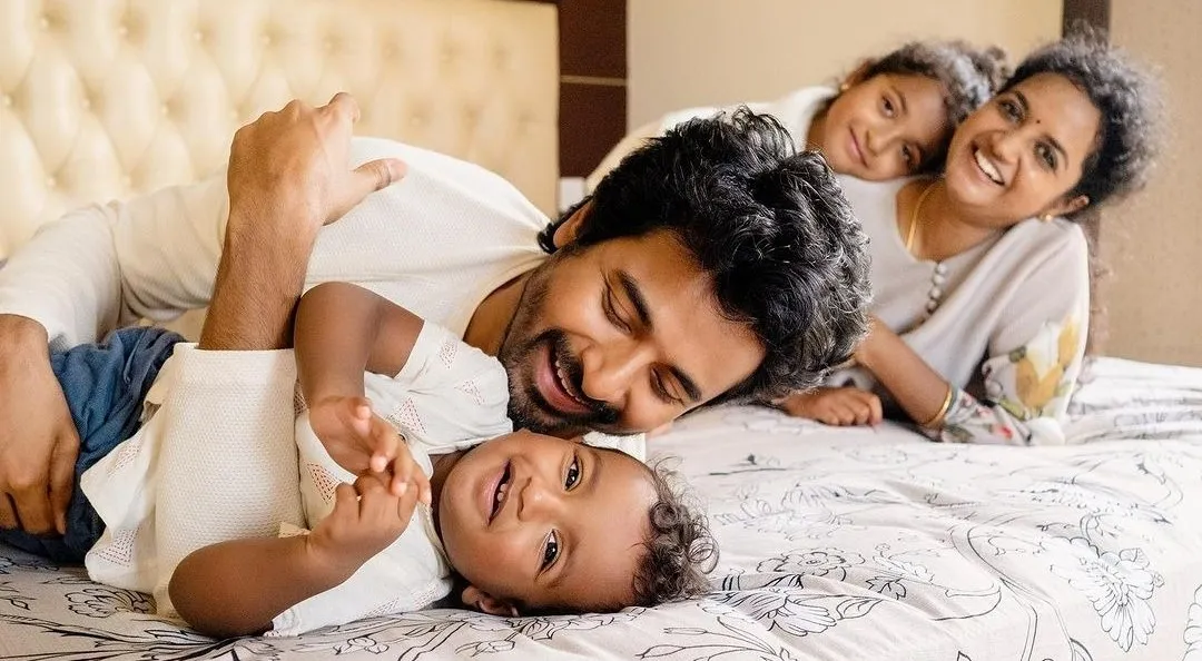 Sk Playing Happily with His Children on the Bed Wallpaper