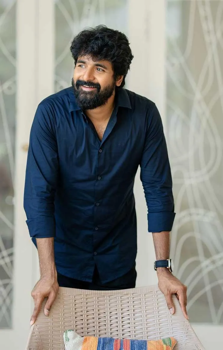 Sk Standing with Dark Blue Shirt Looking Relaxed Wallpaper