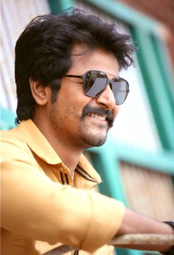 Wallpaper of Sivakarthikeyan in An Orange Shirt and Glasses