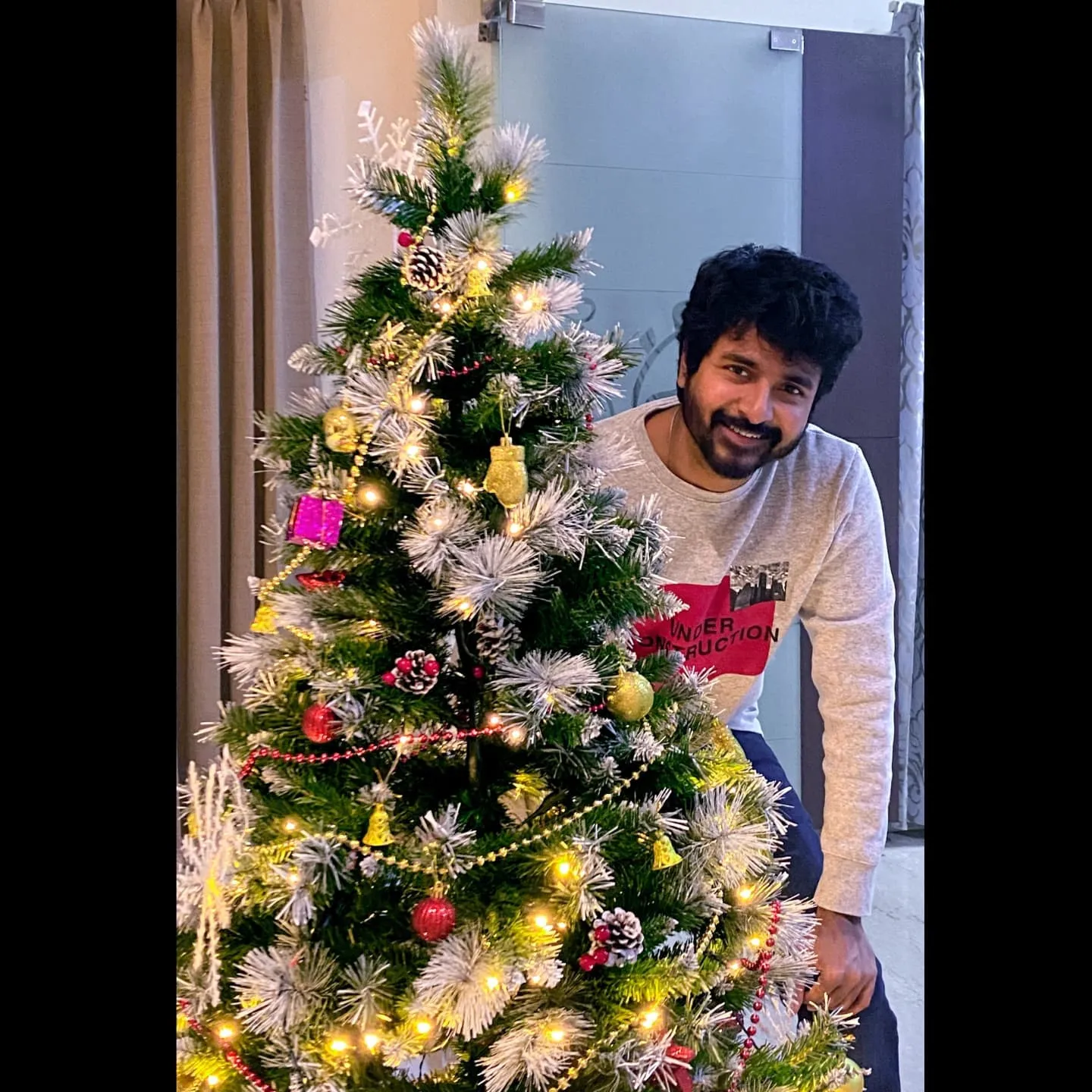 Wallpaper of Sivakarthikeyan Looking from Christmas Tree