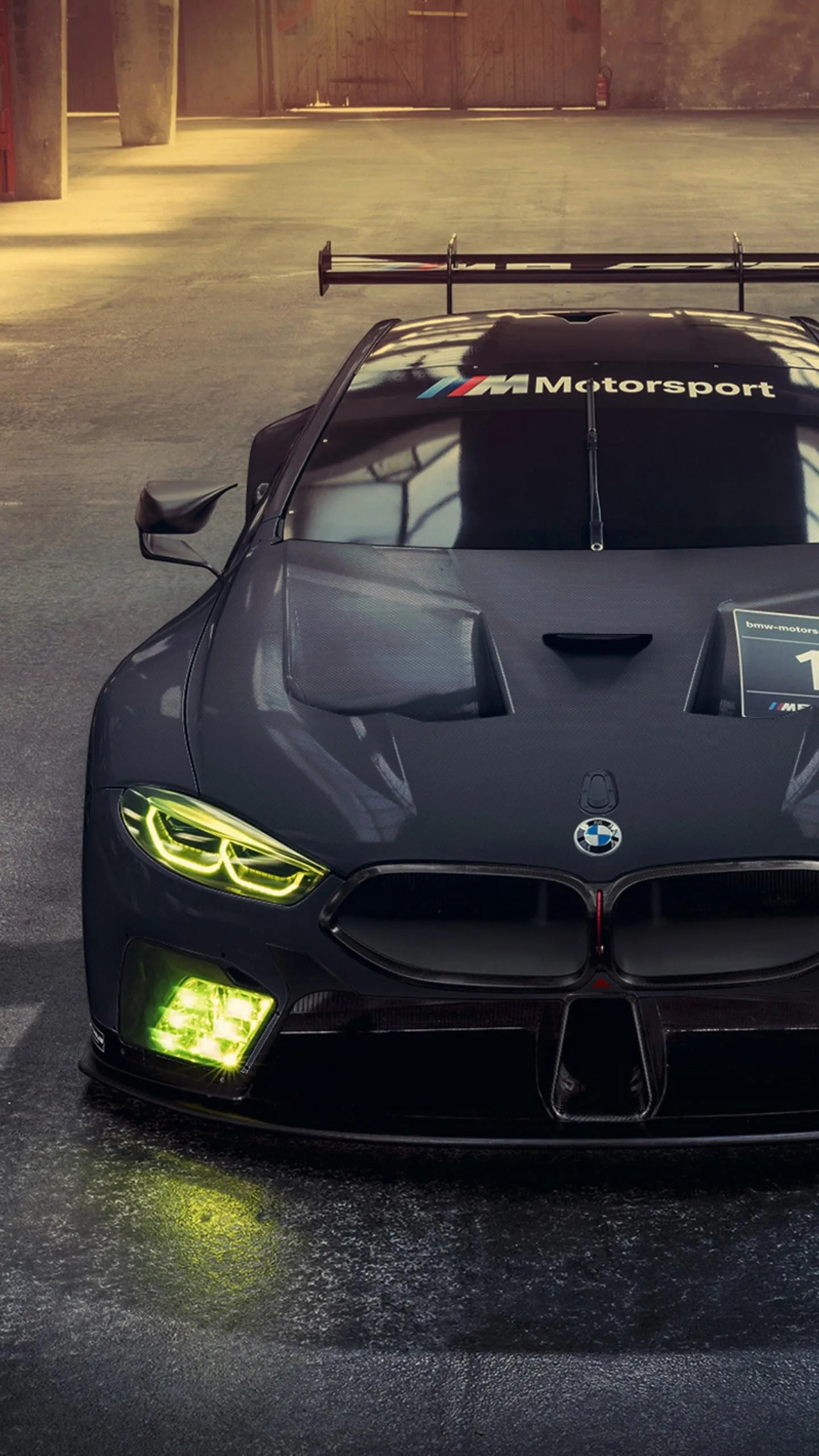 Aggressive Racing Bmw in a Dimly Lit Urban Garage Image