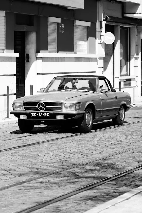 Black and white photo of Mercedes parked on city street