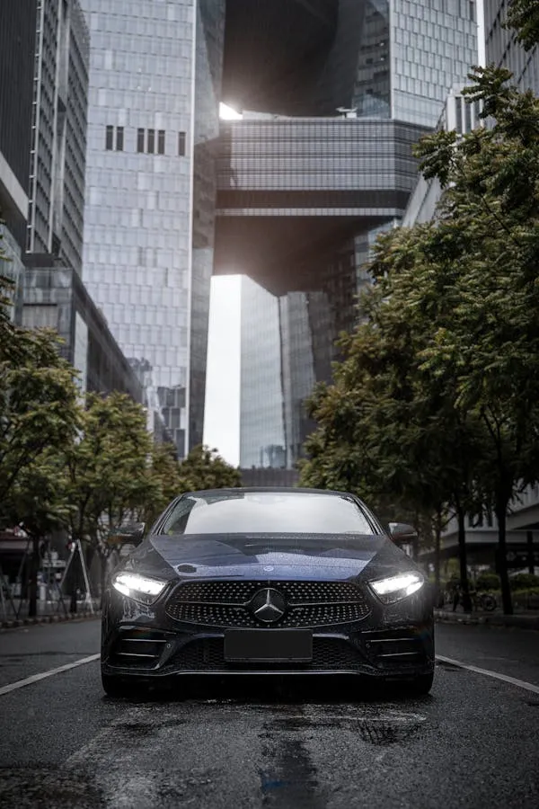 Black Benz Driving Through Skyscraper Urban City Wallpaper