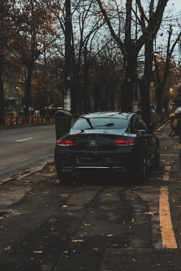 Black Benz Sedan Parked on Leafy City Side Street Wallpaper