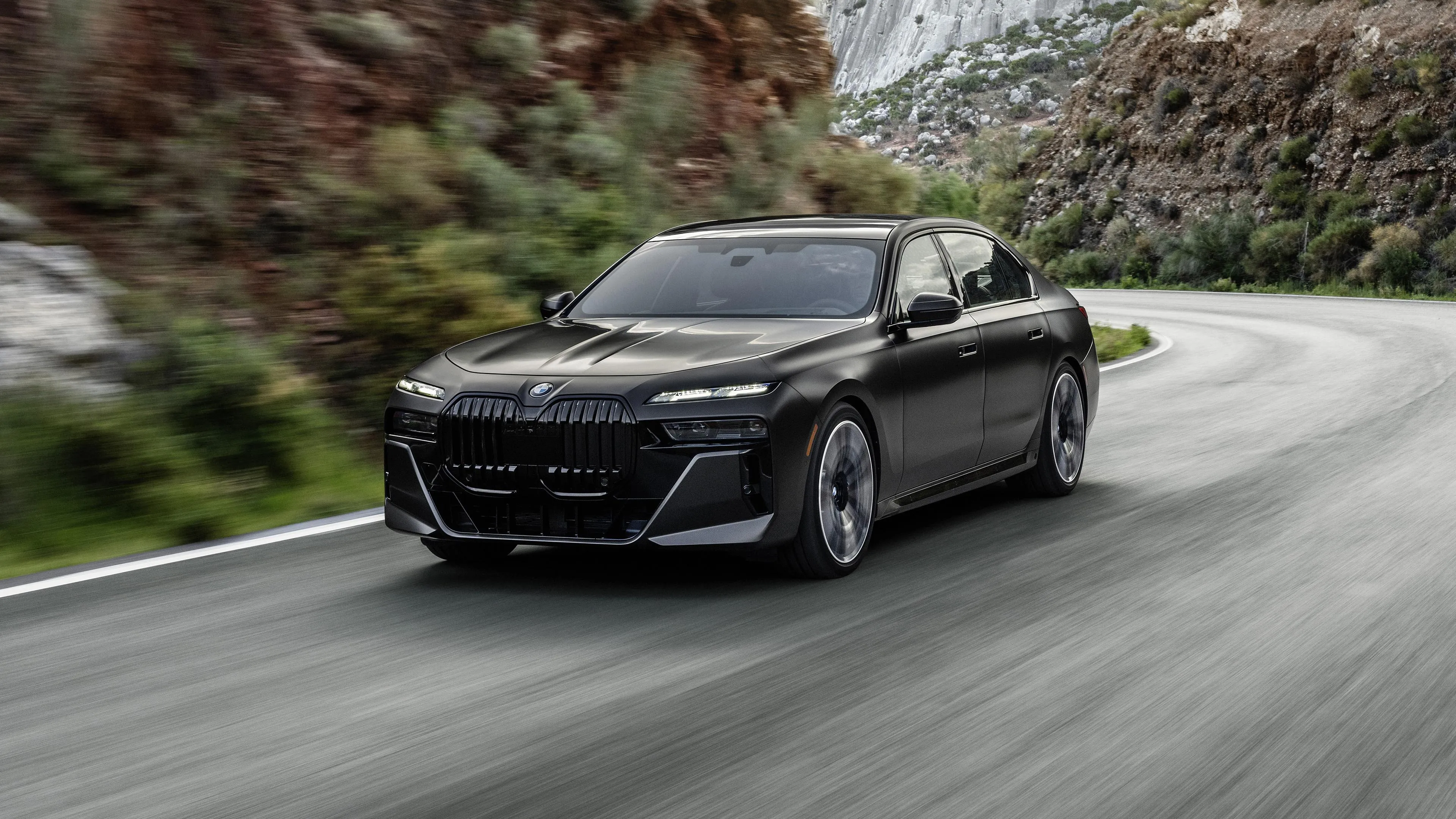Black Bmw Car Driving Through Forested Mountain Road