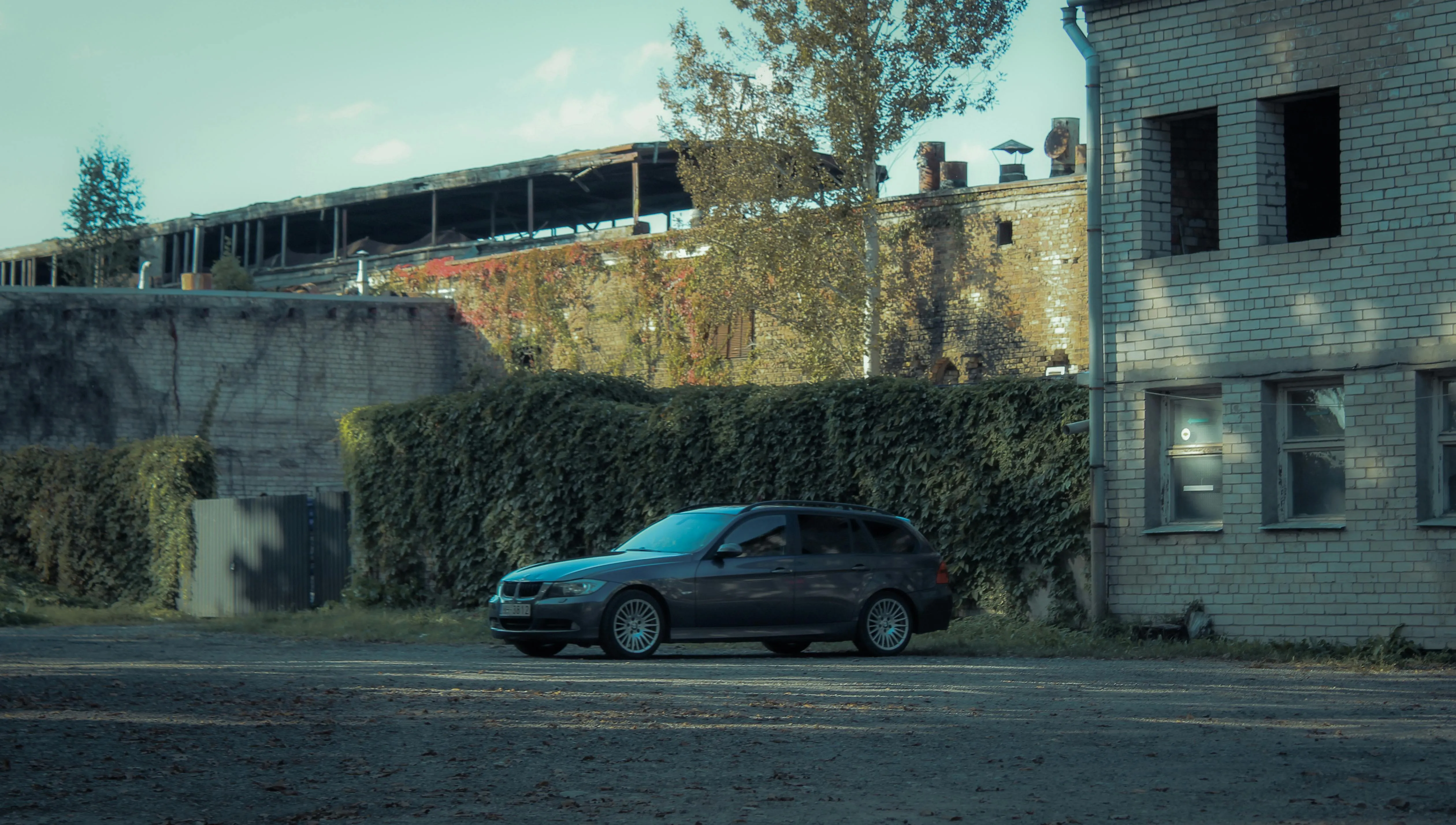 Black Bmw Car Near Abandoned Building in Moody Lighting