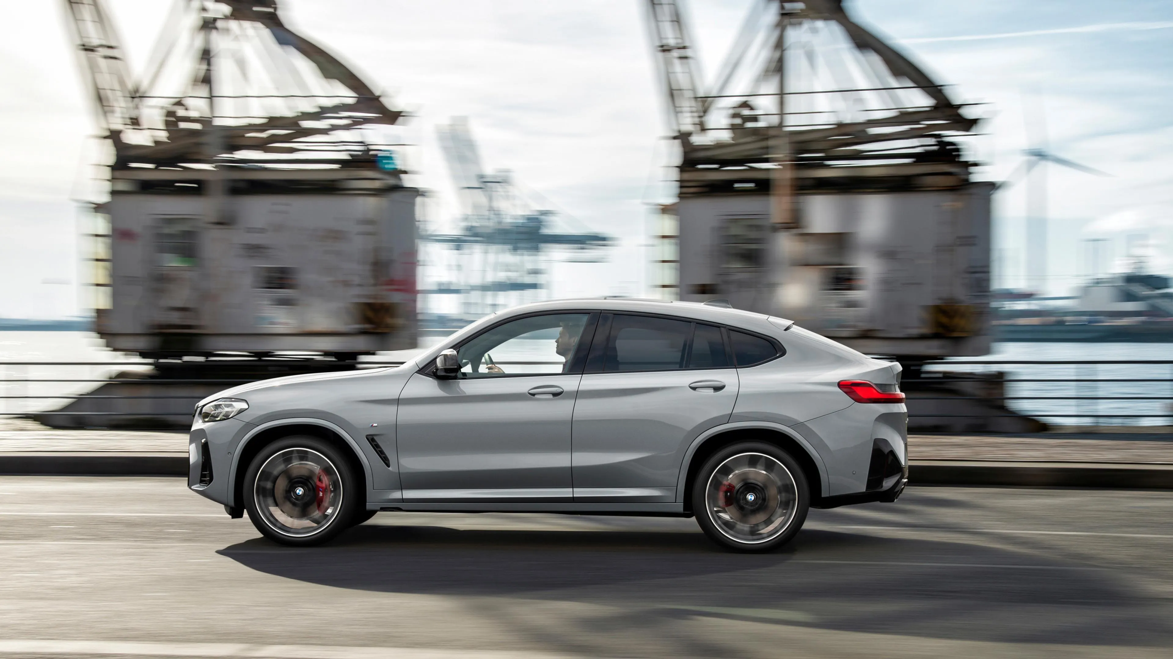 Black Bmw Coupe Driving Past Industrial Harbor Area