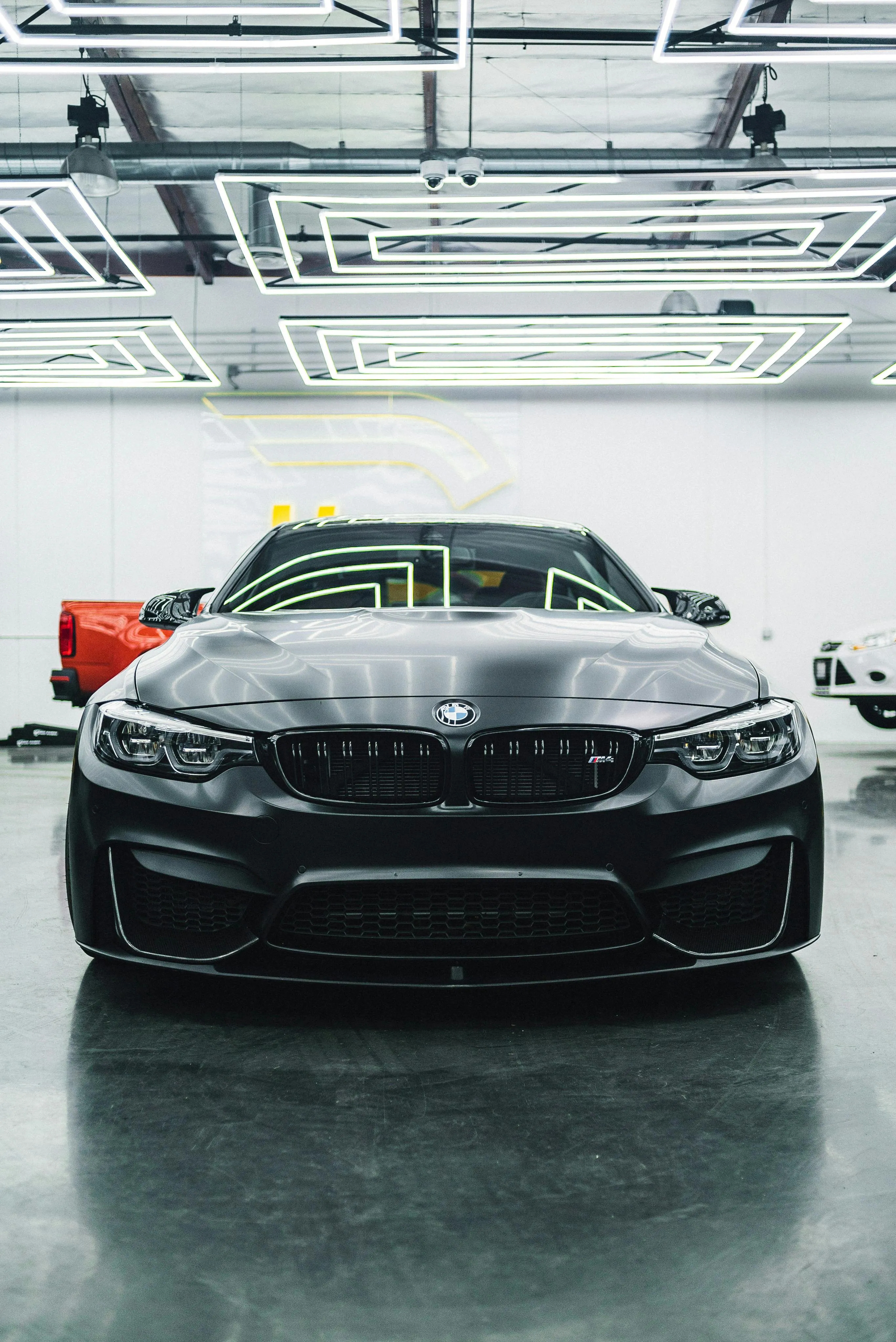 Black Bmw in a Clean Garage with Bright Overhead Lighting