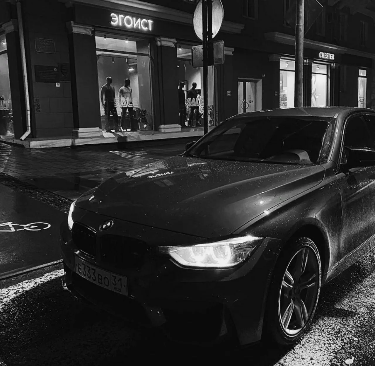 Black Bmw in Rainy Night Street Scene with Urban Background