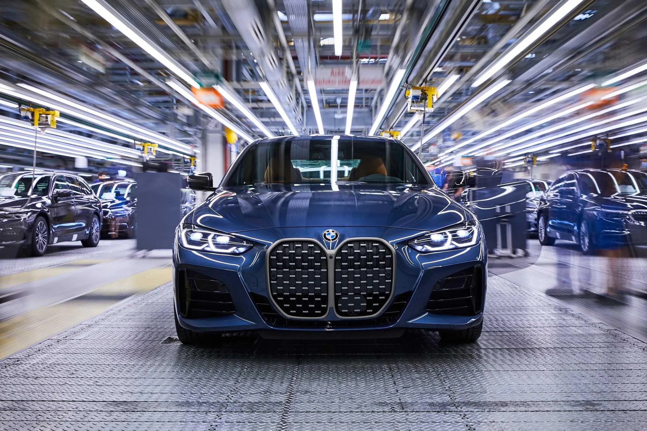 Black Bmw on Factory Floor Under Bright Industrial Lights