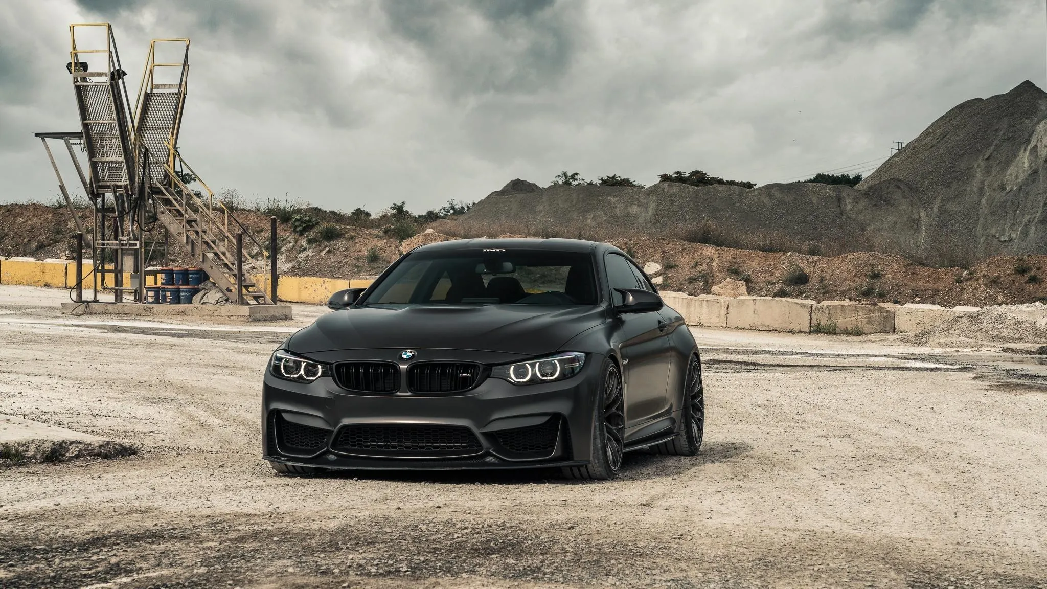 Black Bmw Parked on Rough Terrain Under Cloudy Skies