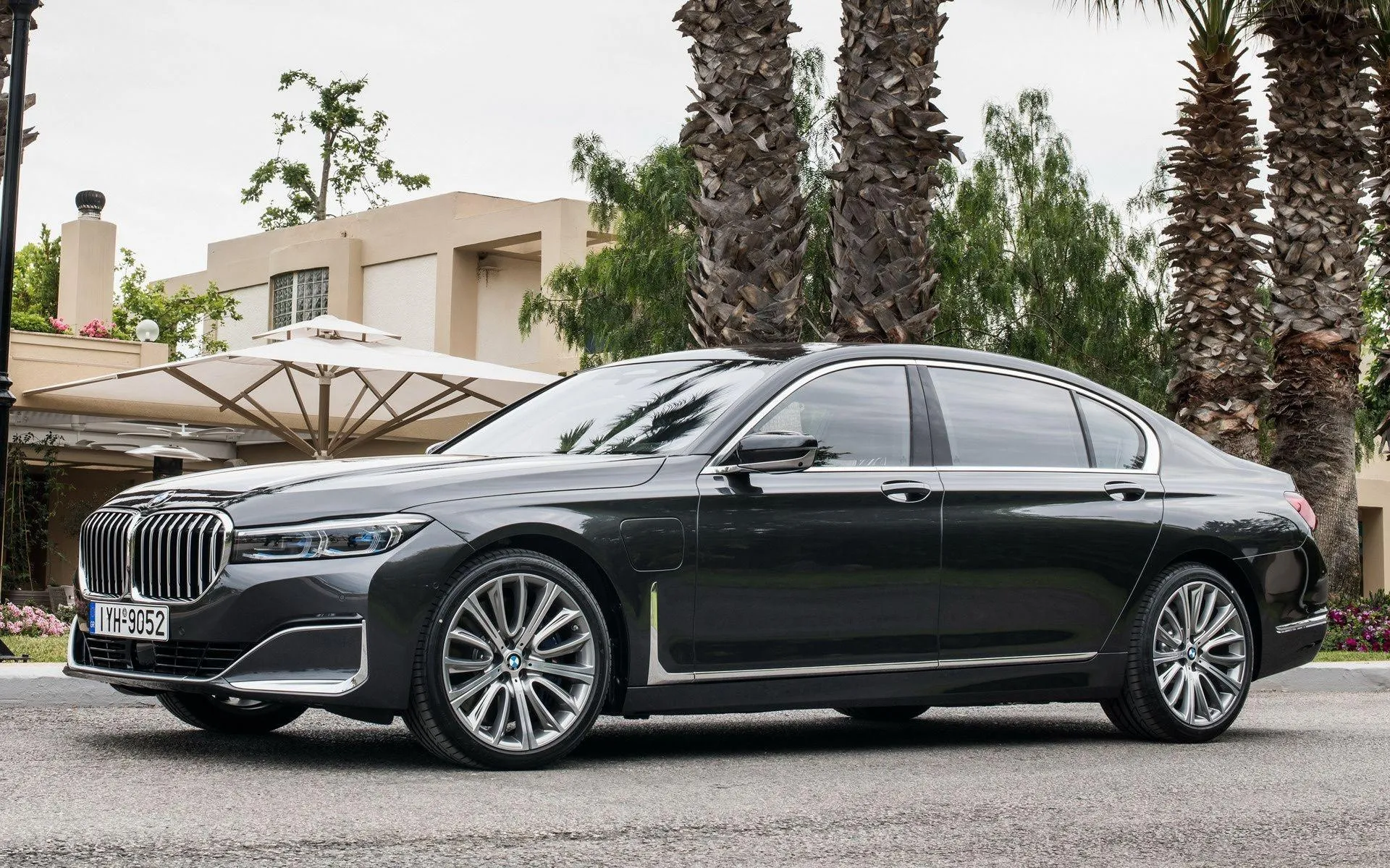 Black Bmw Parked Outside Luxury Home with Palm Trees Image