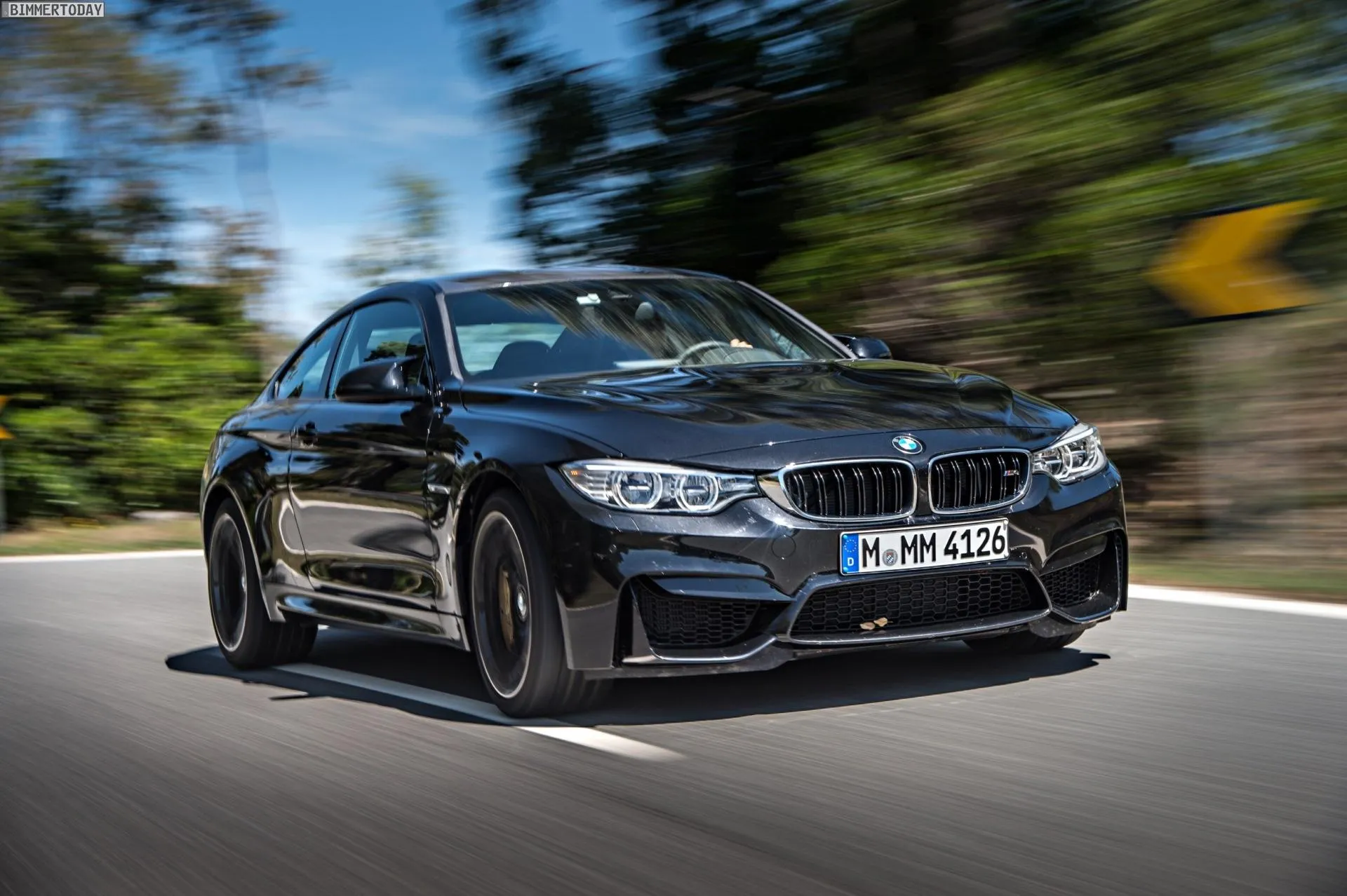 Black Bmw Sedan Driving Fast on a Winding Forest Road
