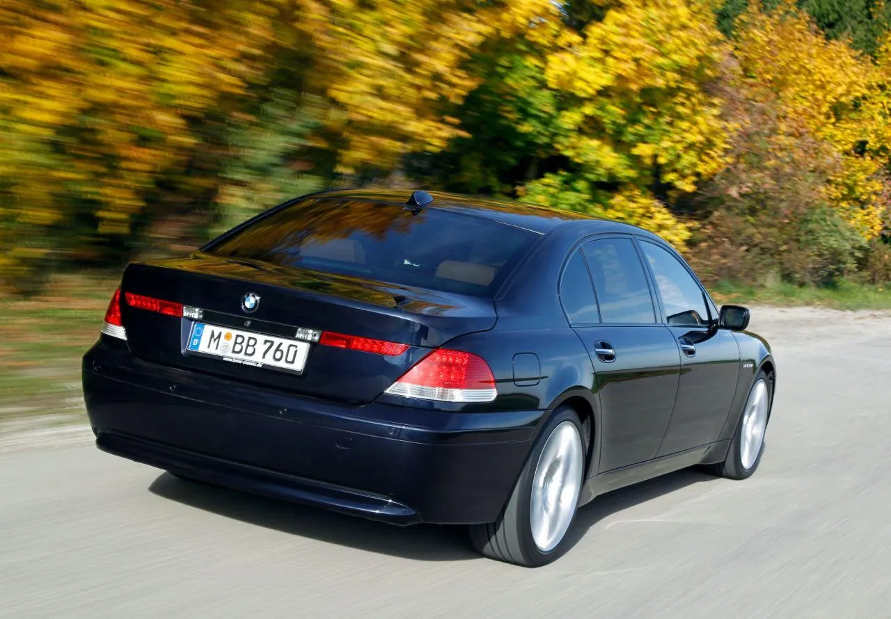 Black Bmw Sedan Driving on Road with Trees in Background