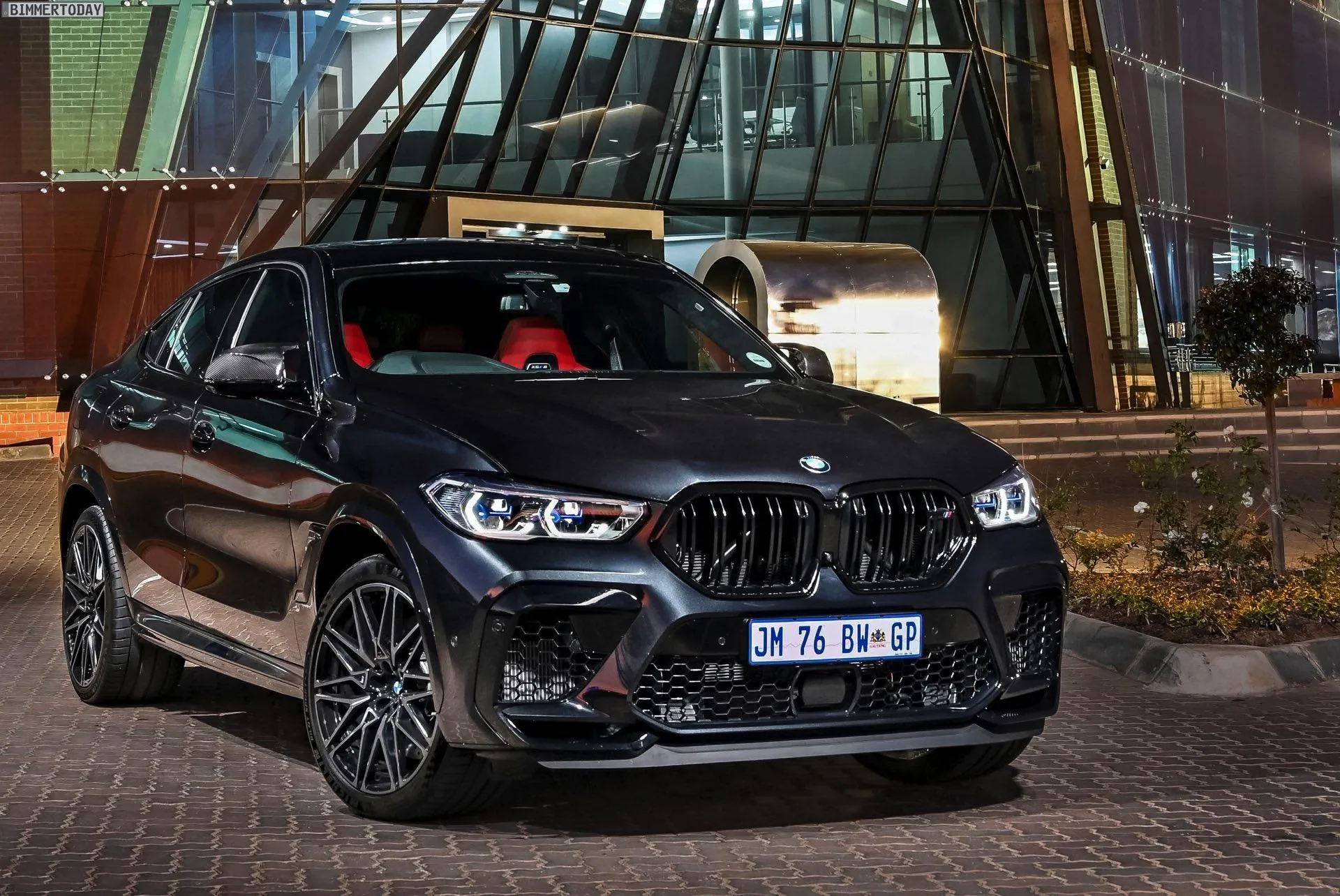 Black Bmw Sports Car Parked Near Glass Building at Night