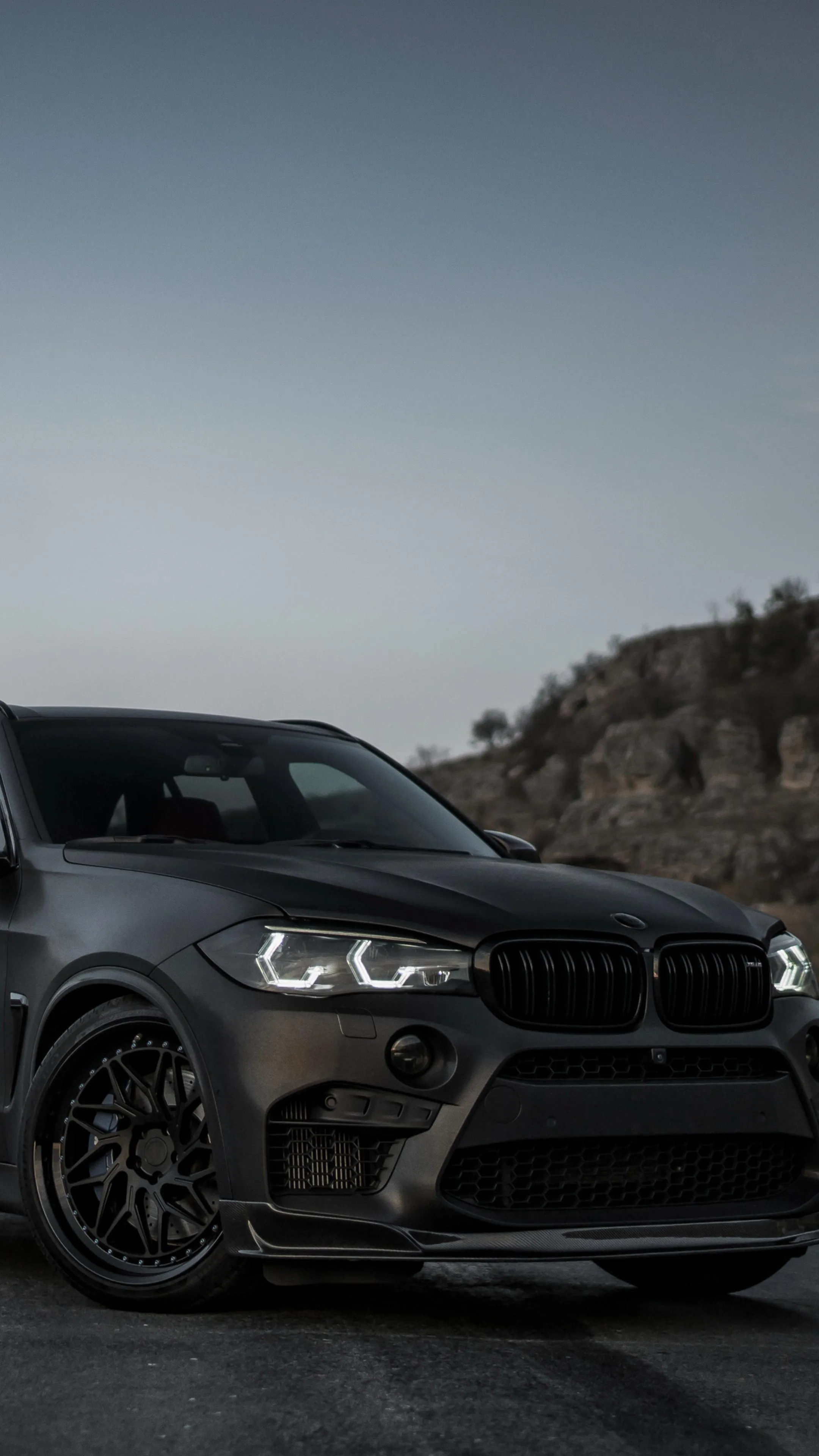 Black Bmw Sports Car Parked Near Hills at Dusk Wallpaper