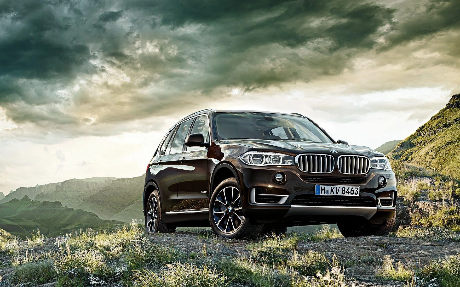 Black Bmw Suv Driving Through Mountain Road Curves
