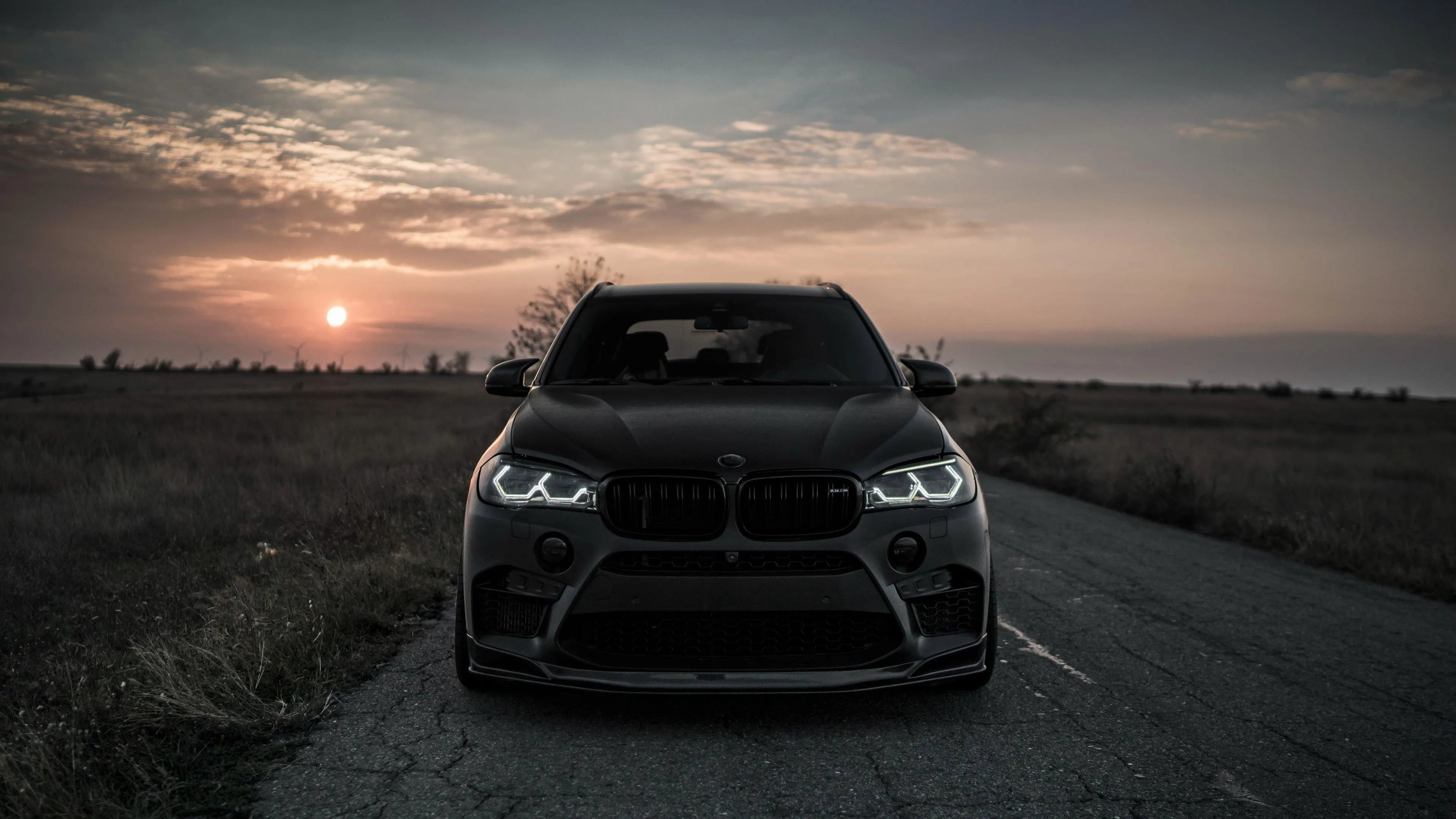 Black Bmw Suv Parked at Sunset with Scenic Background