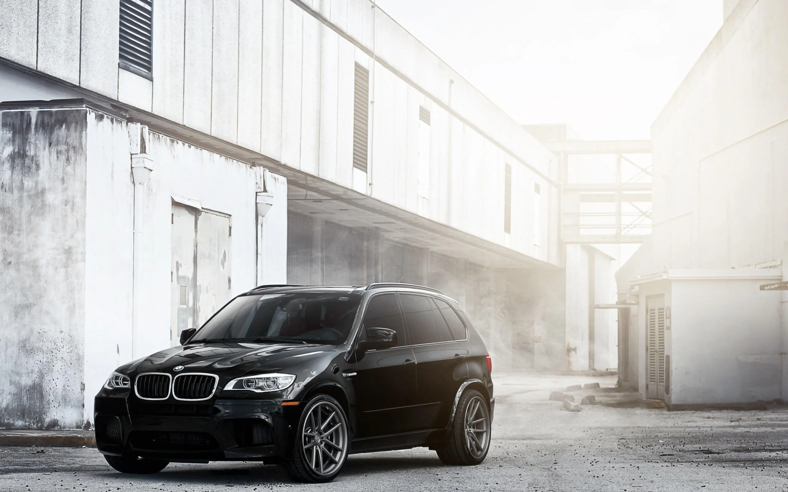 Black Bmw Suv Parked in Sunlit Urban Alley Wallpaper