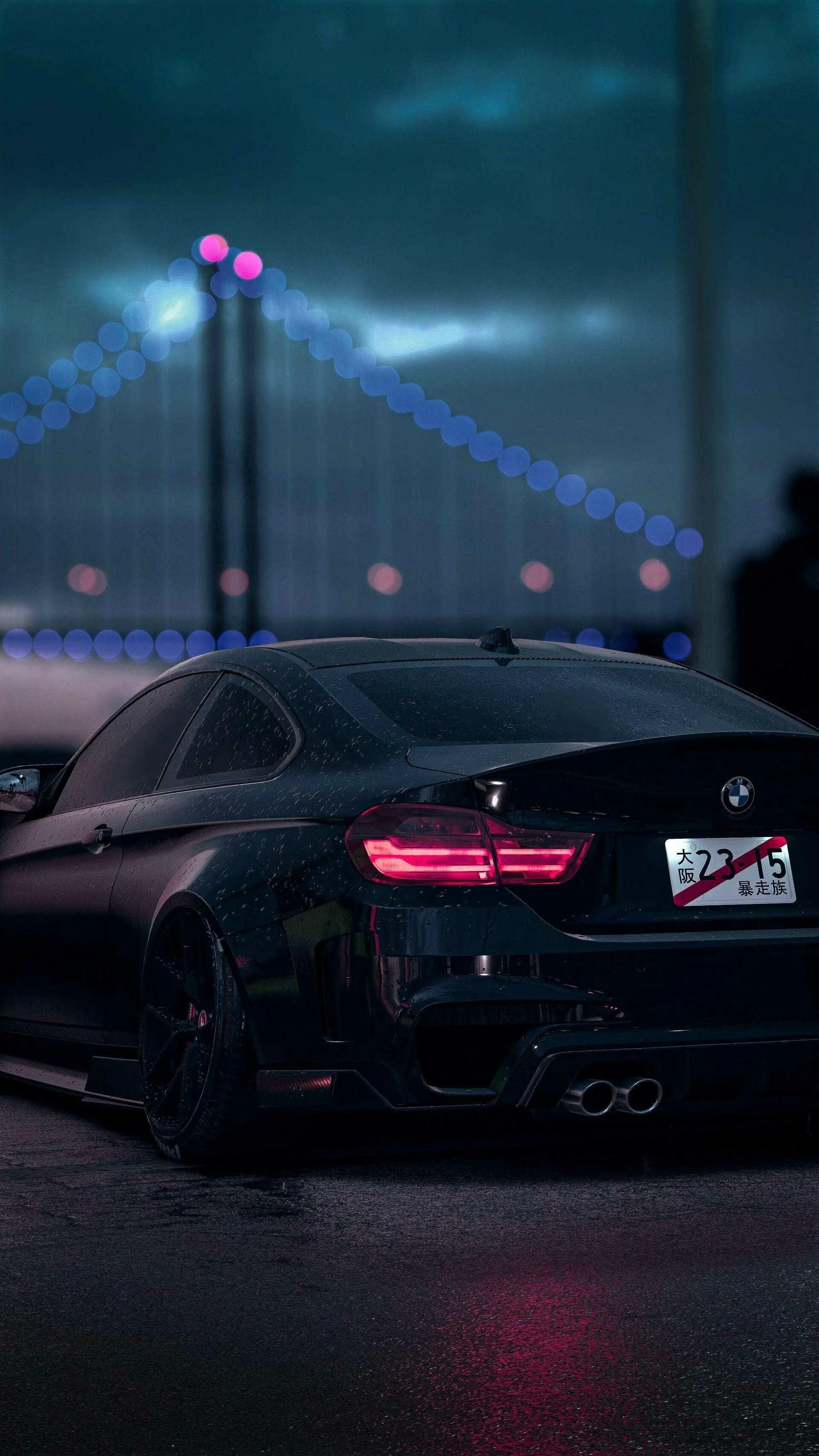 Black Bmw with Glowing Taillights Near Suspension Bridge