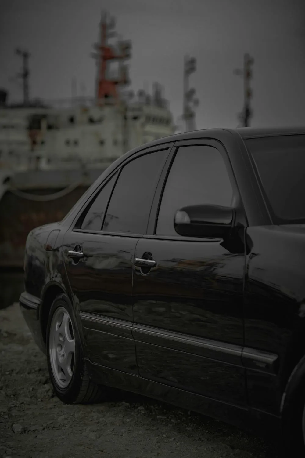 Black luxury Mercedes parked in industrial dock setting