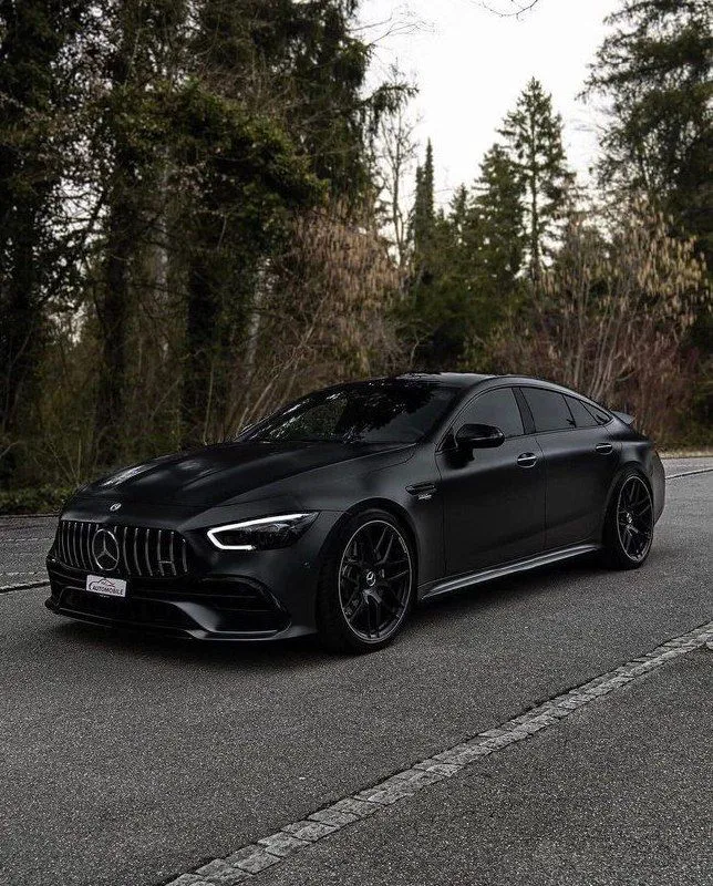 Black Mercedes Benz Driving on a Forest Side Roadway