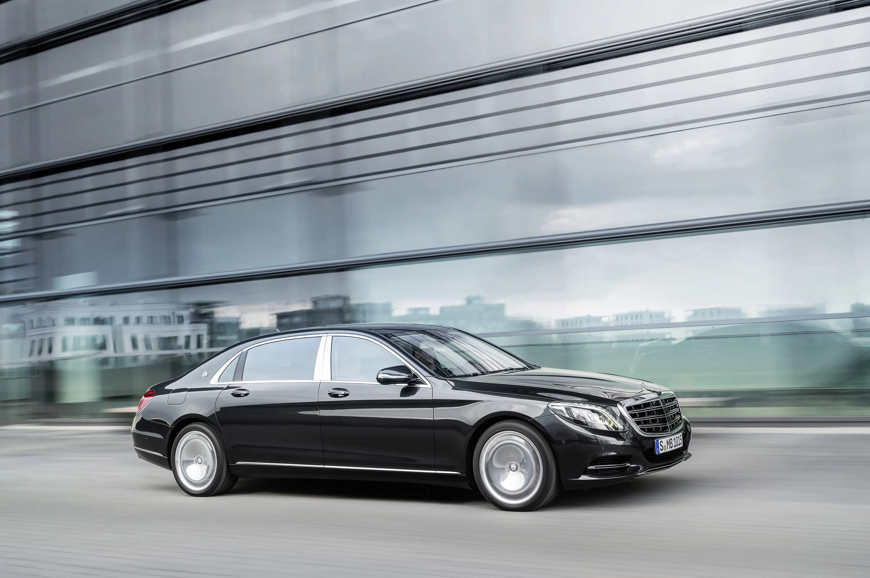 Black Mercedes Benz Luxury Sedan Driving Fast near building