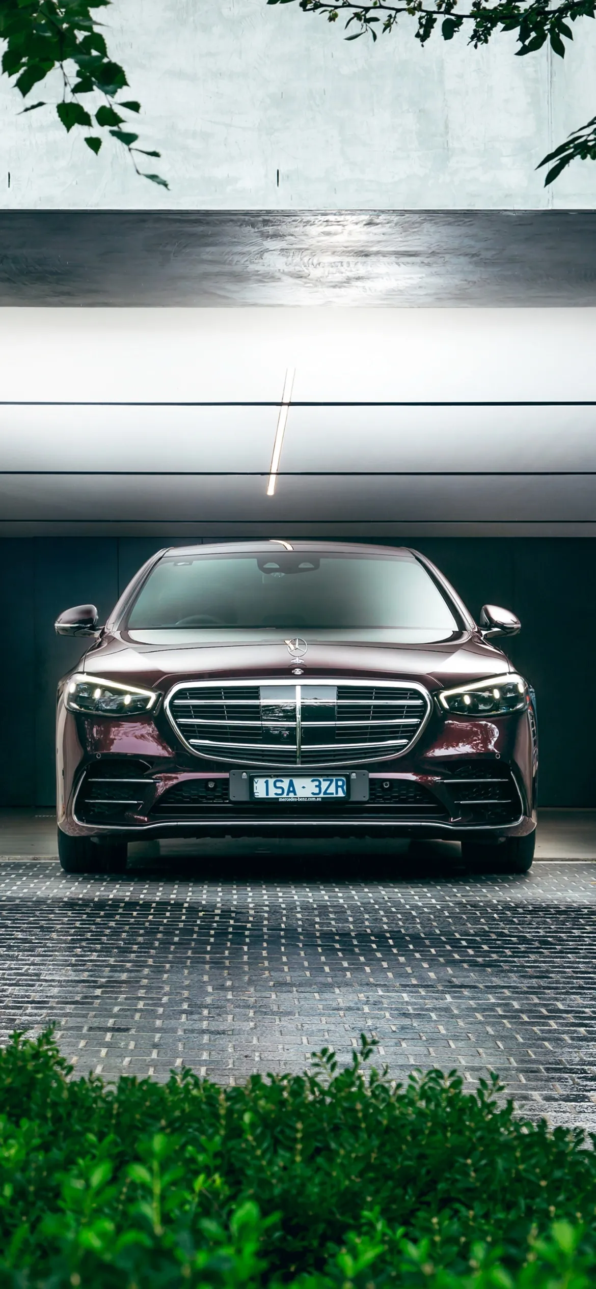 Black Mercedes Benz Luxury Sedan Parked by Water with Trees