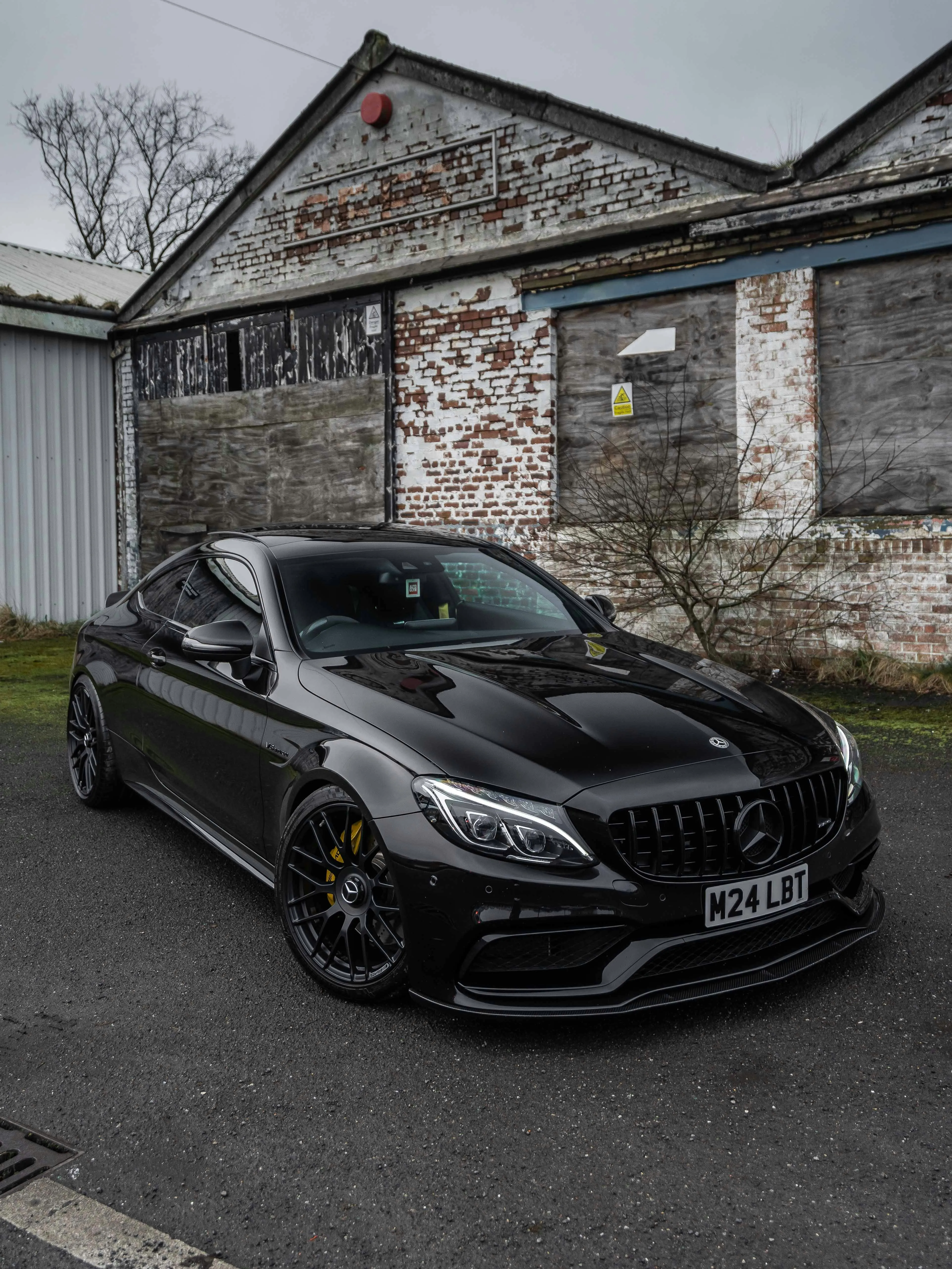 Black Mercedes Benz Parked by Old Rustic Building