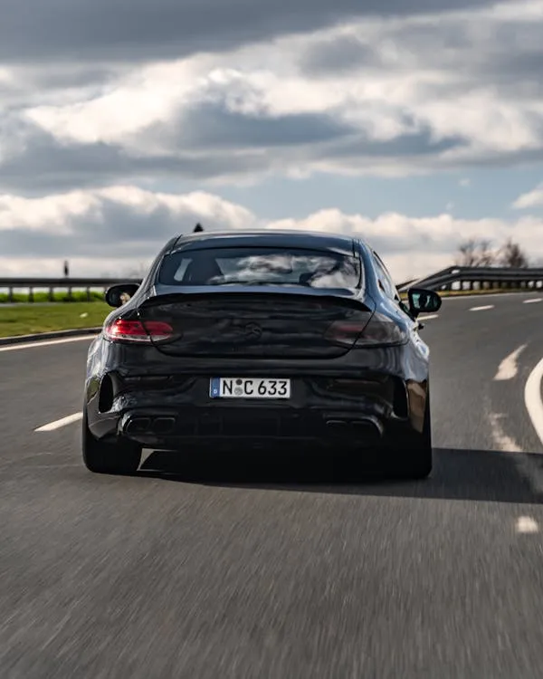 Black Mercedes Benz Sedan Driving on Curved Road Wallpaper