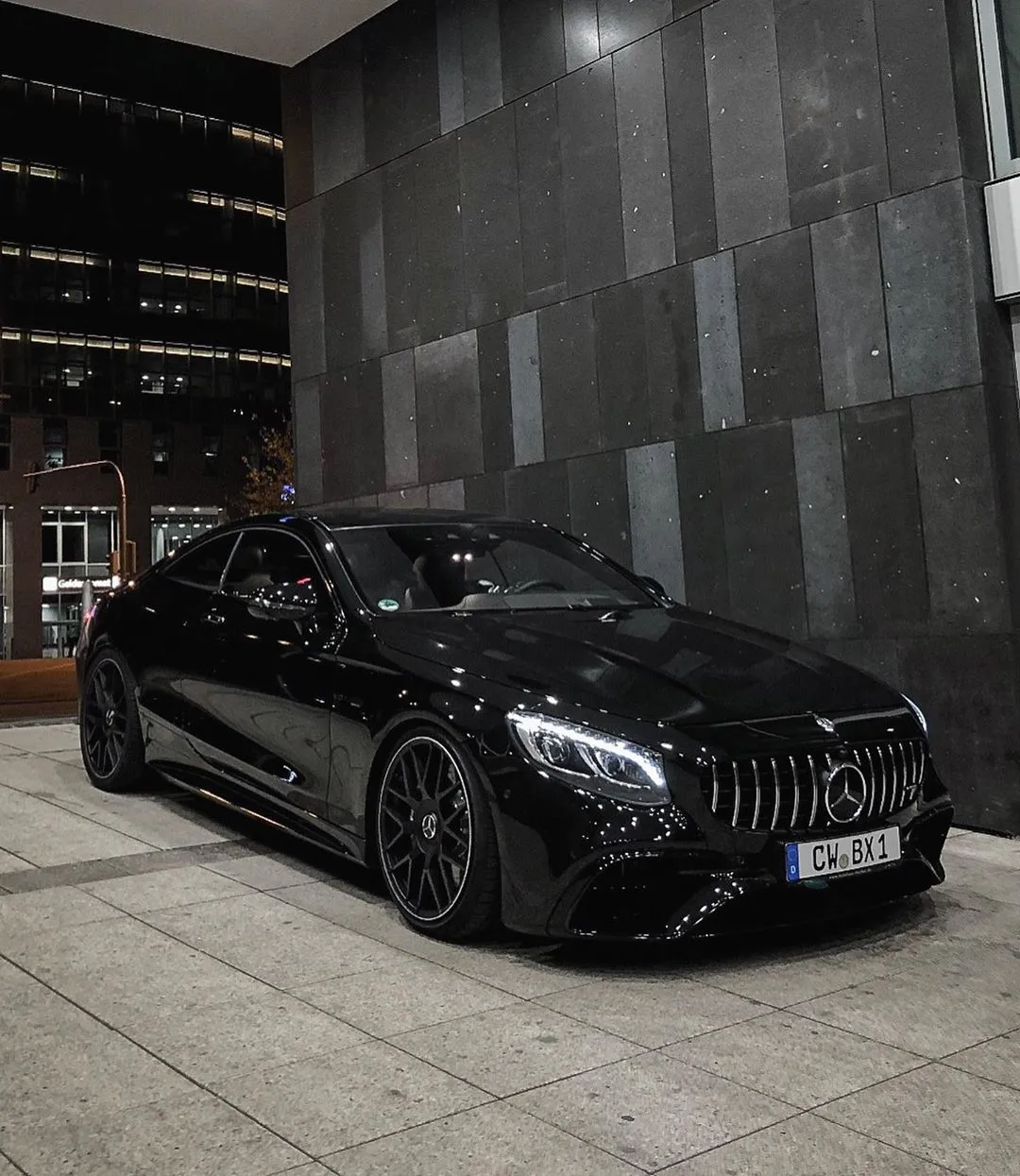 Black Mercedes Benz Sedan in Front of Modern Building