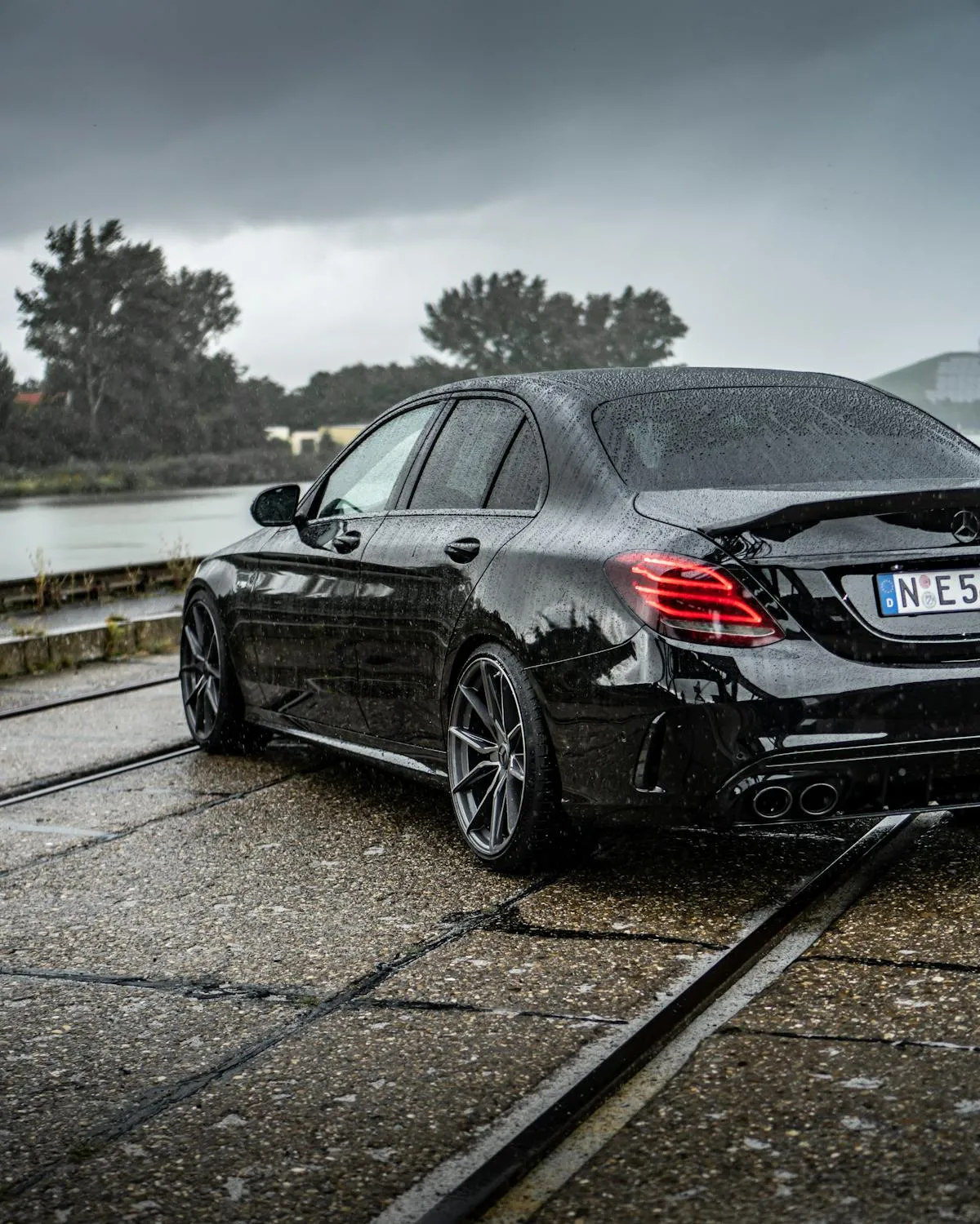 Black Mercedes Benz Sedan on Wet Railroad Tracks image