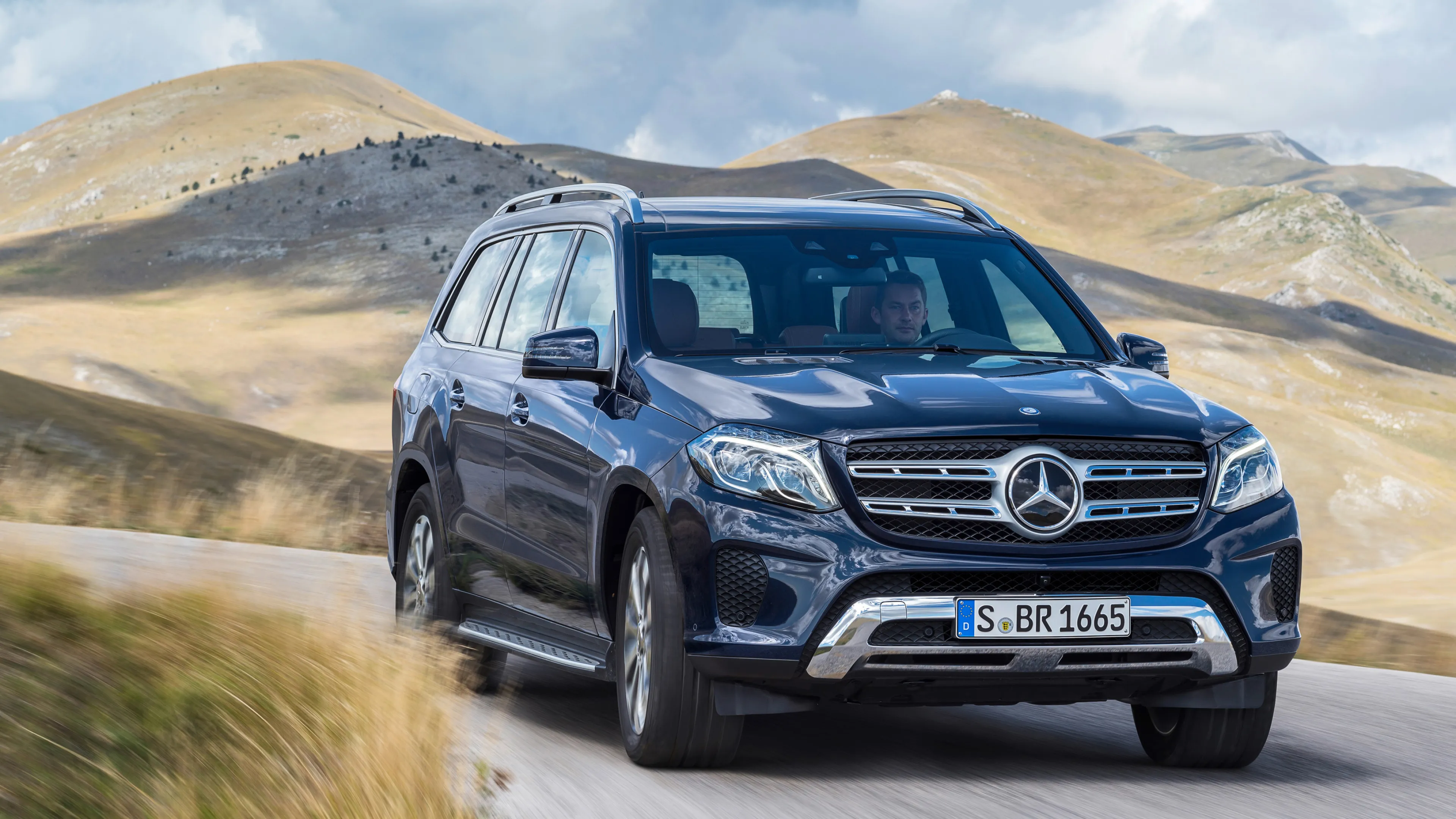 Black Mercedes Benz SUV Moving Through Mountain Terrain