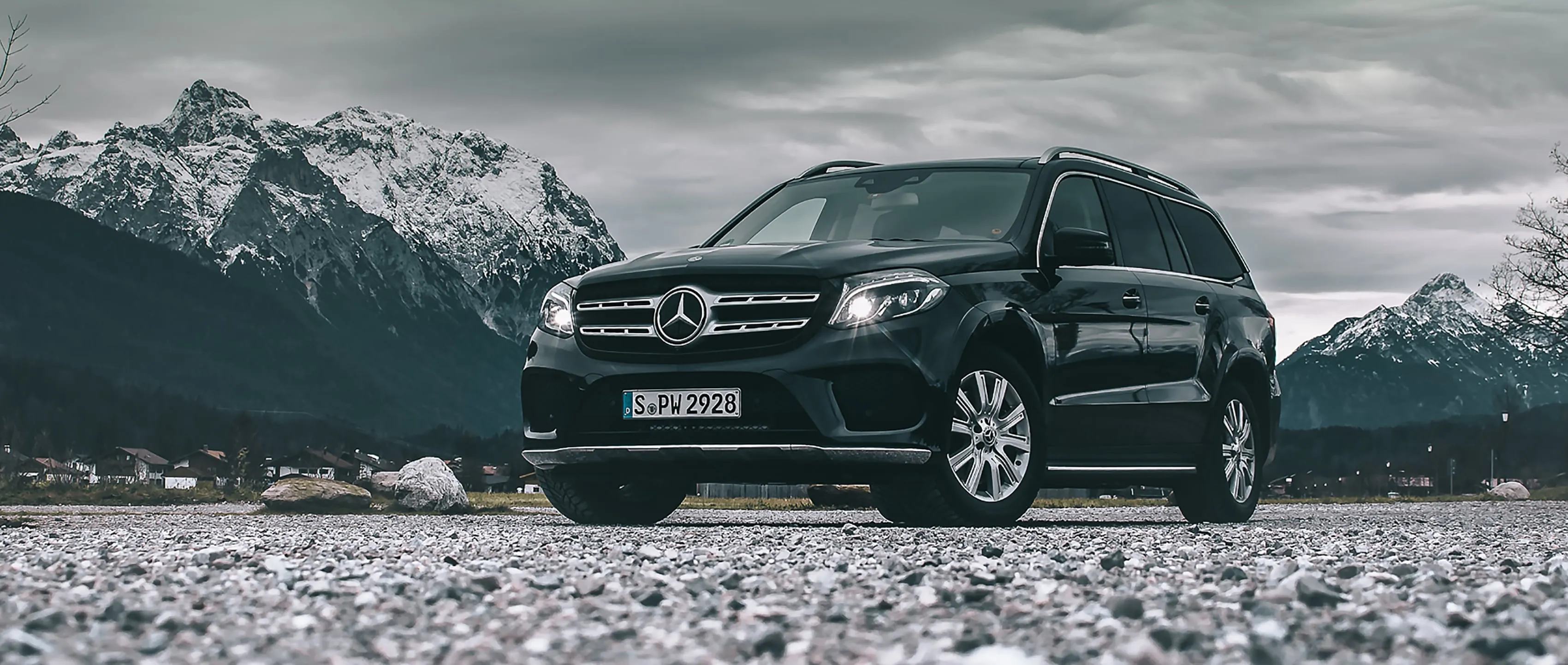 Black Mercedes Benz SUV Parked by Snowy Mountain Range
