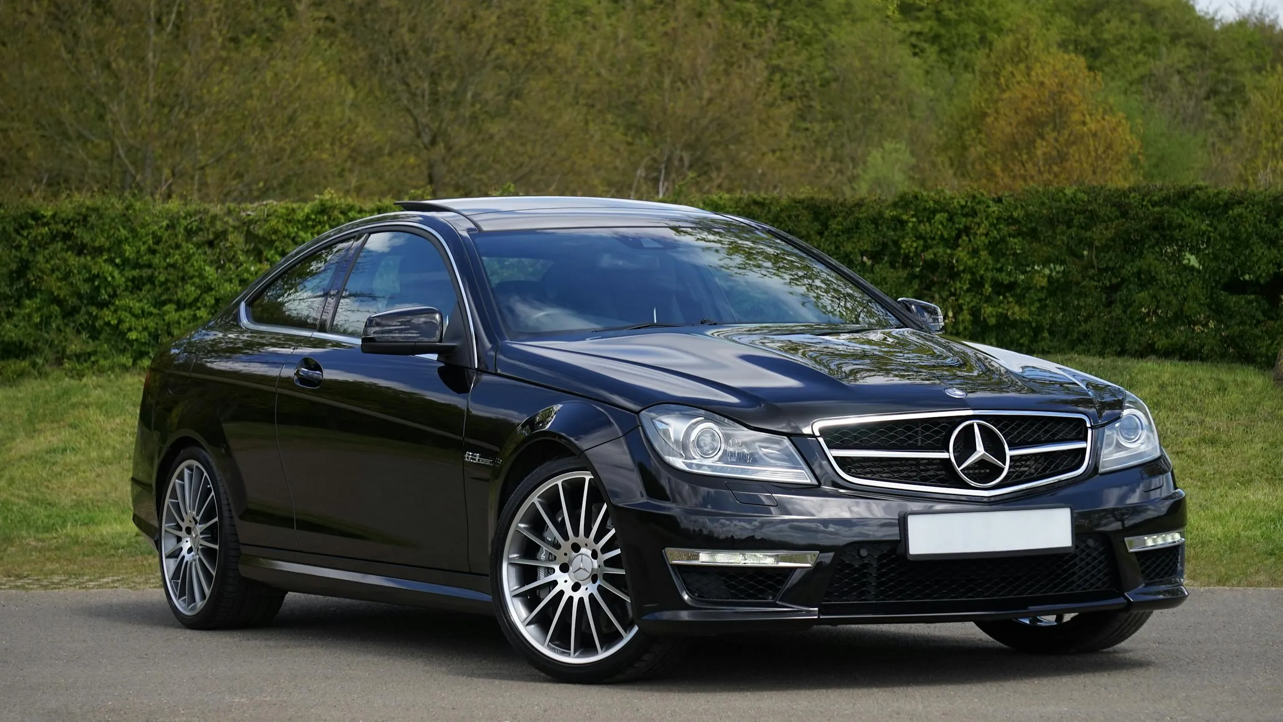 Black Mercedes Coupe Parked On Green Grass Wallpaper