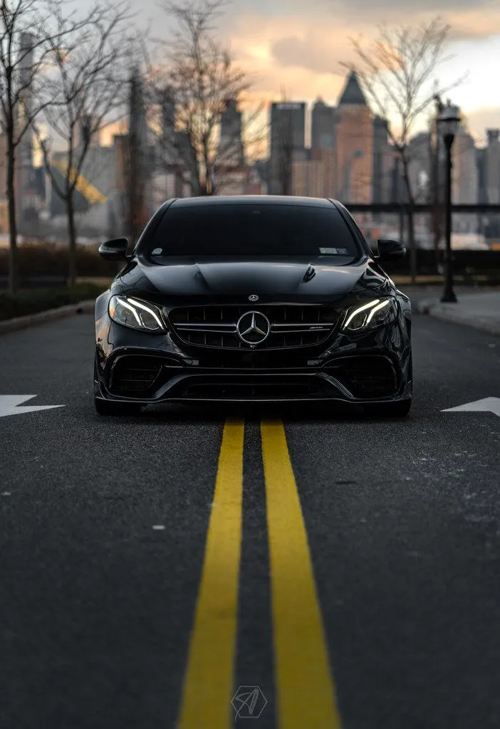 Black Mercedes Driving Down Center Line City Road Wallpaper
