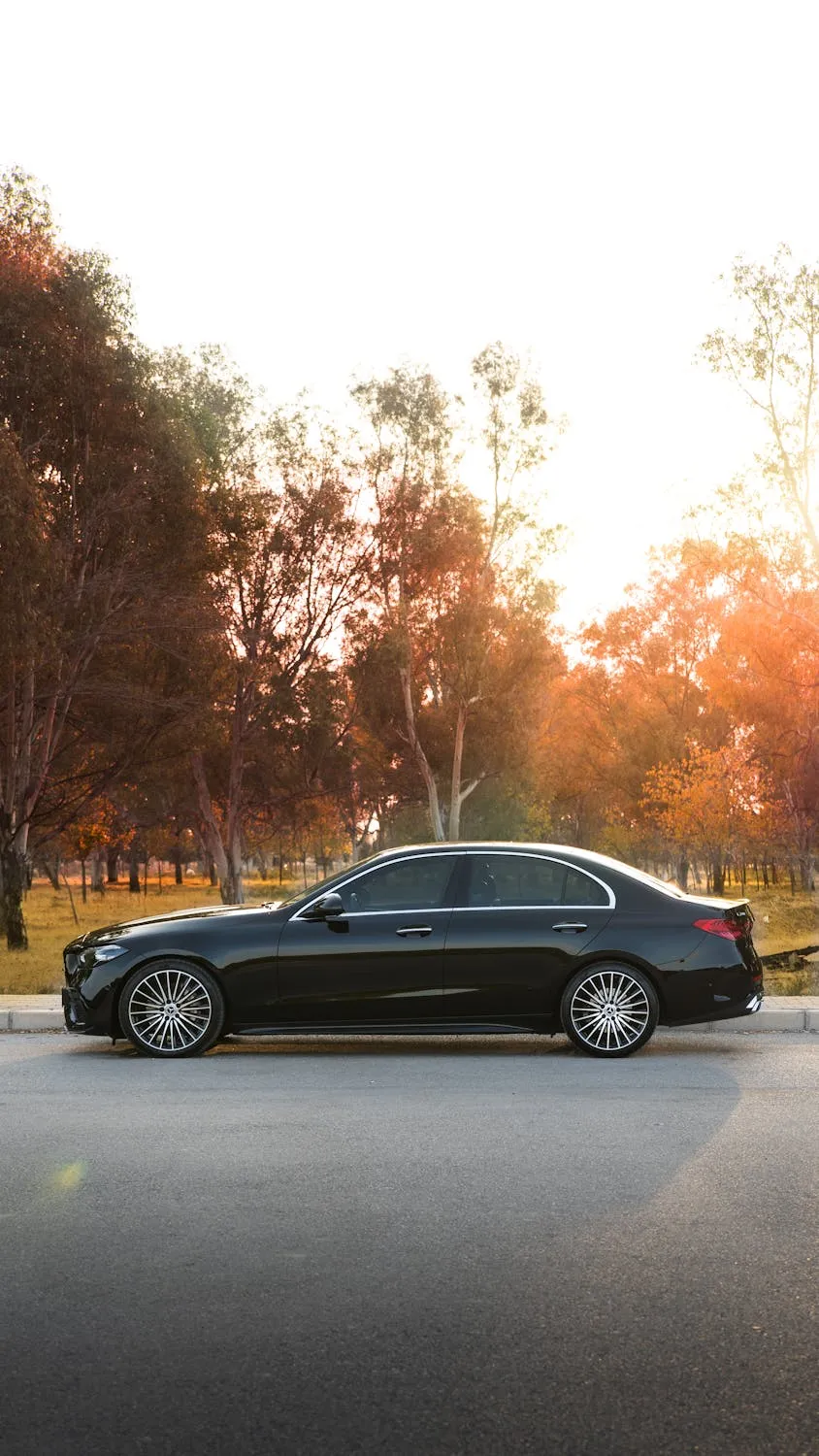 Black Mercedes Sedan in Autumn Sunset Setting Wallpaper