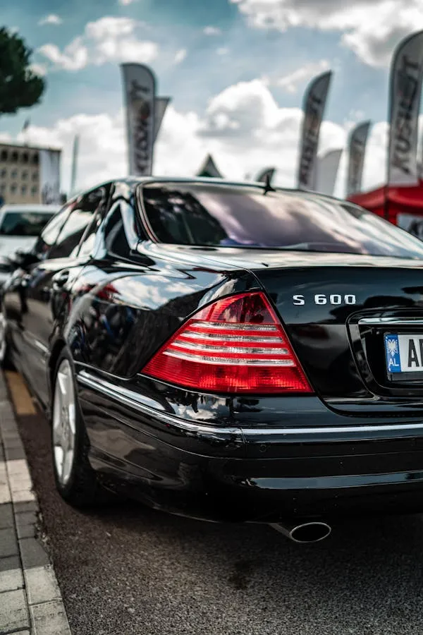 Black S Class Mercedes parked in busy outdoor dealership