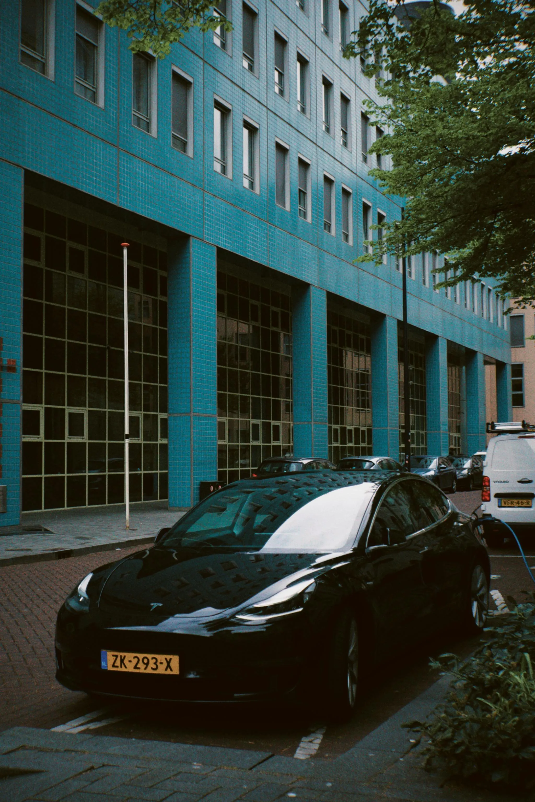 Black Tesla Model X Parked Outside Blue Building HD download