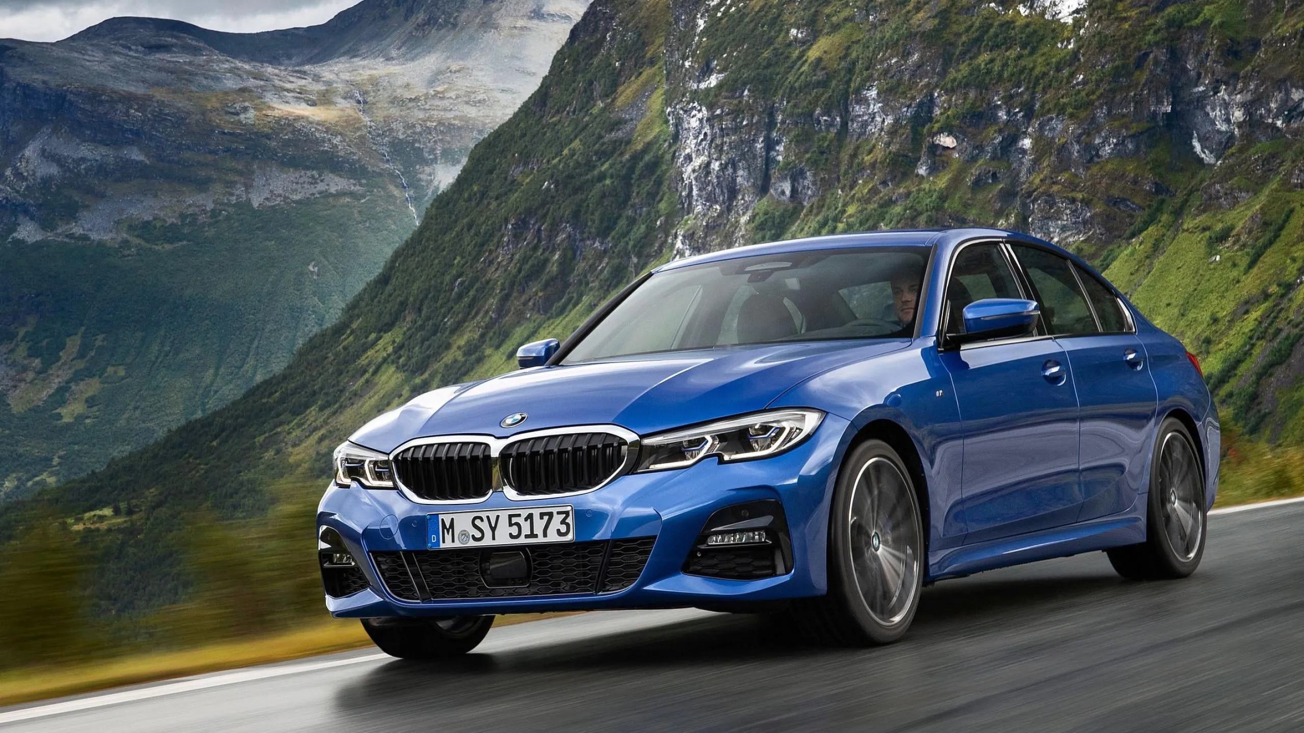 Blue Bmw Car Driving Near a Mountain Valley Hd Image