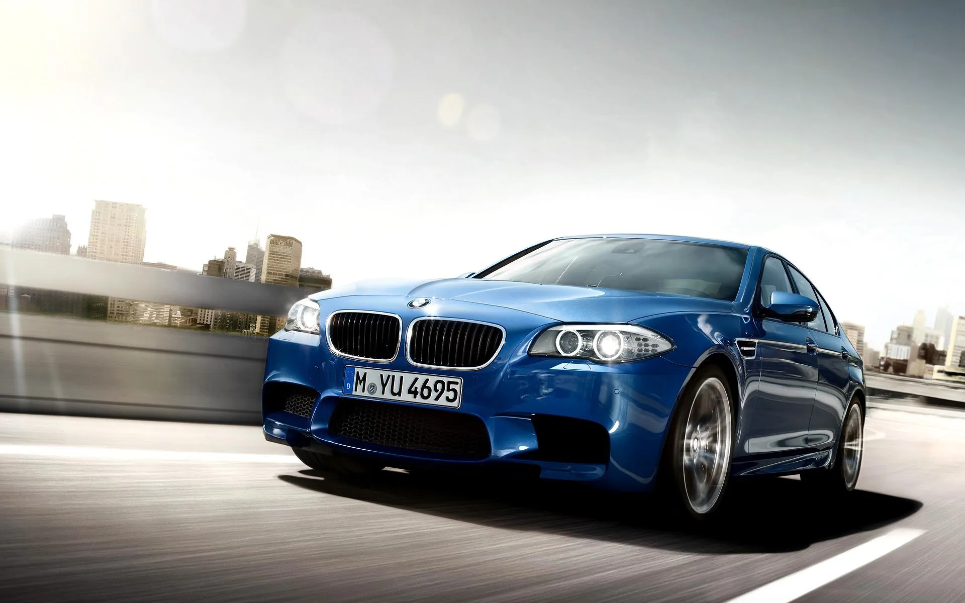 Blue Bmw Car Speeding on a City Road with Blurred Background