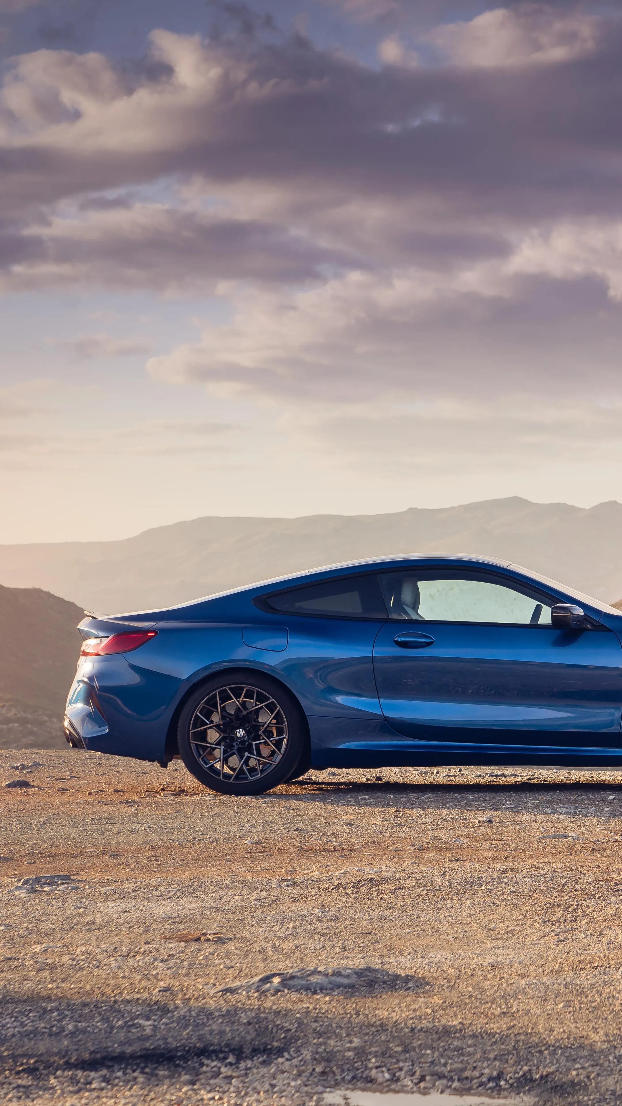 Blue Bmw Coupe Parked Near Coastline Under a Sunset Sky