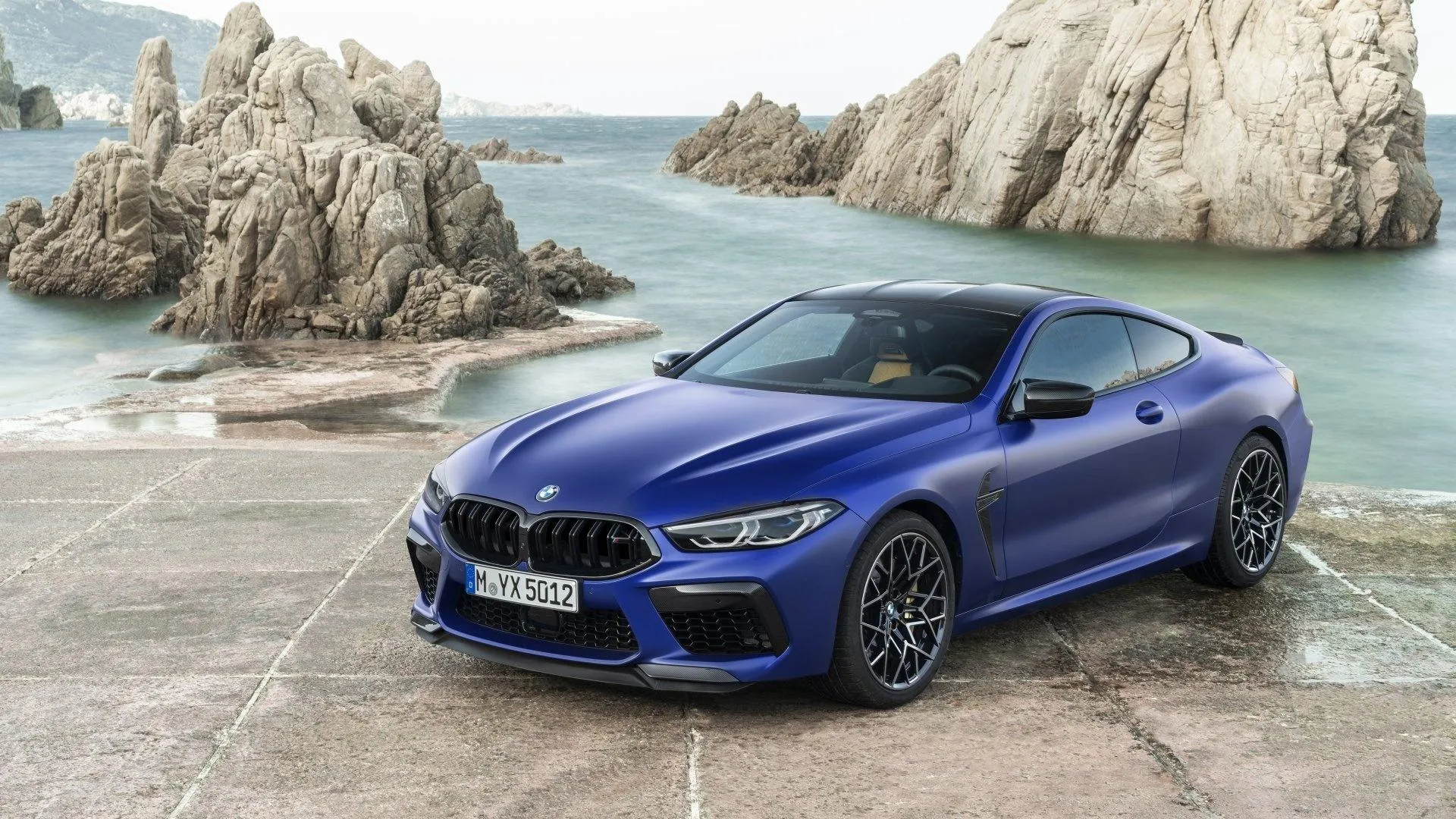 Blue Bmw Coupe Parked on Rocky Shore By the Ocean Image