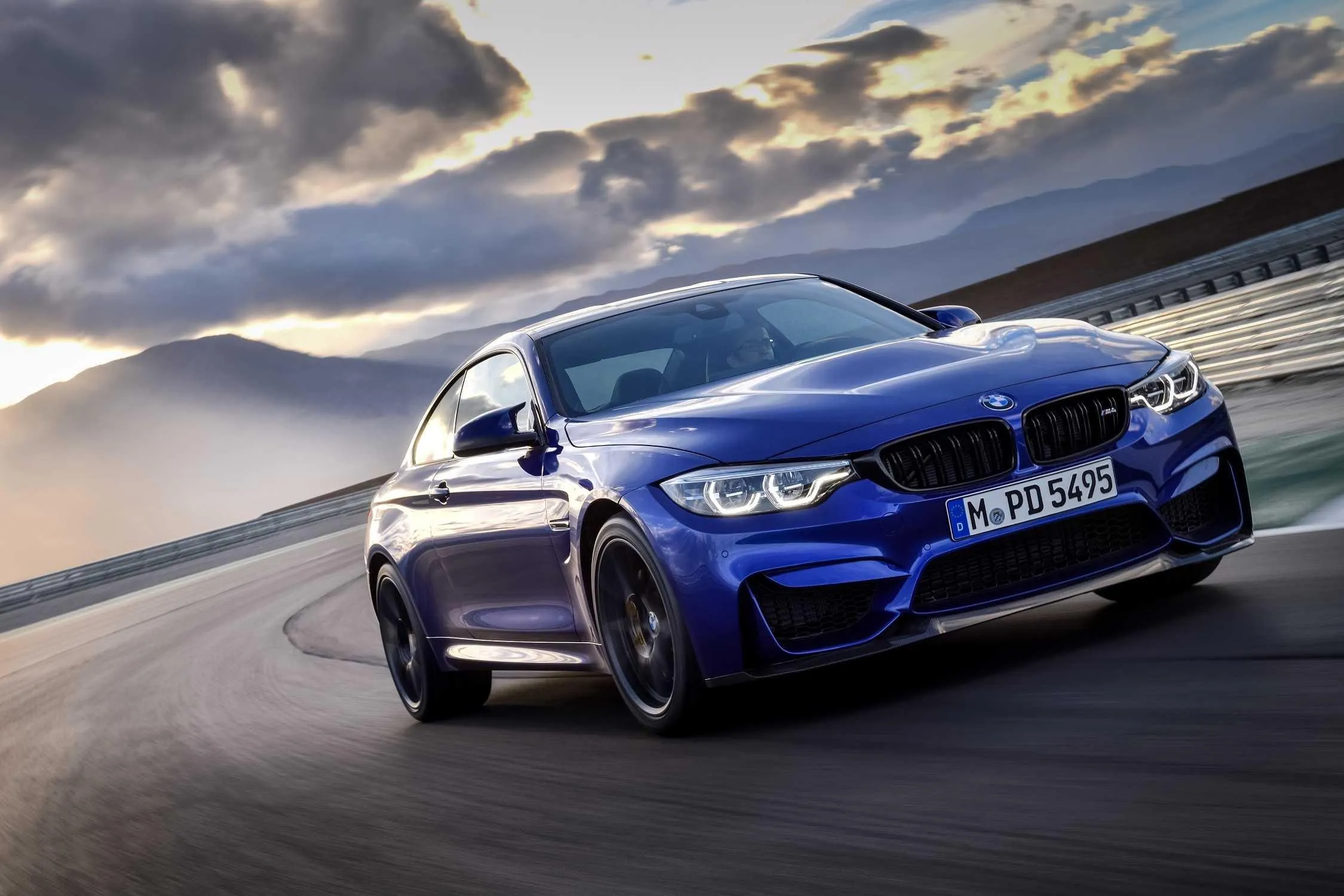 Blue Bmw Drifting at Sunset on Wide Racetrack Wallpaper