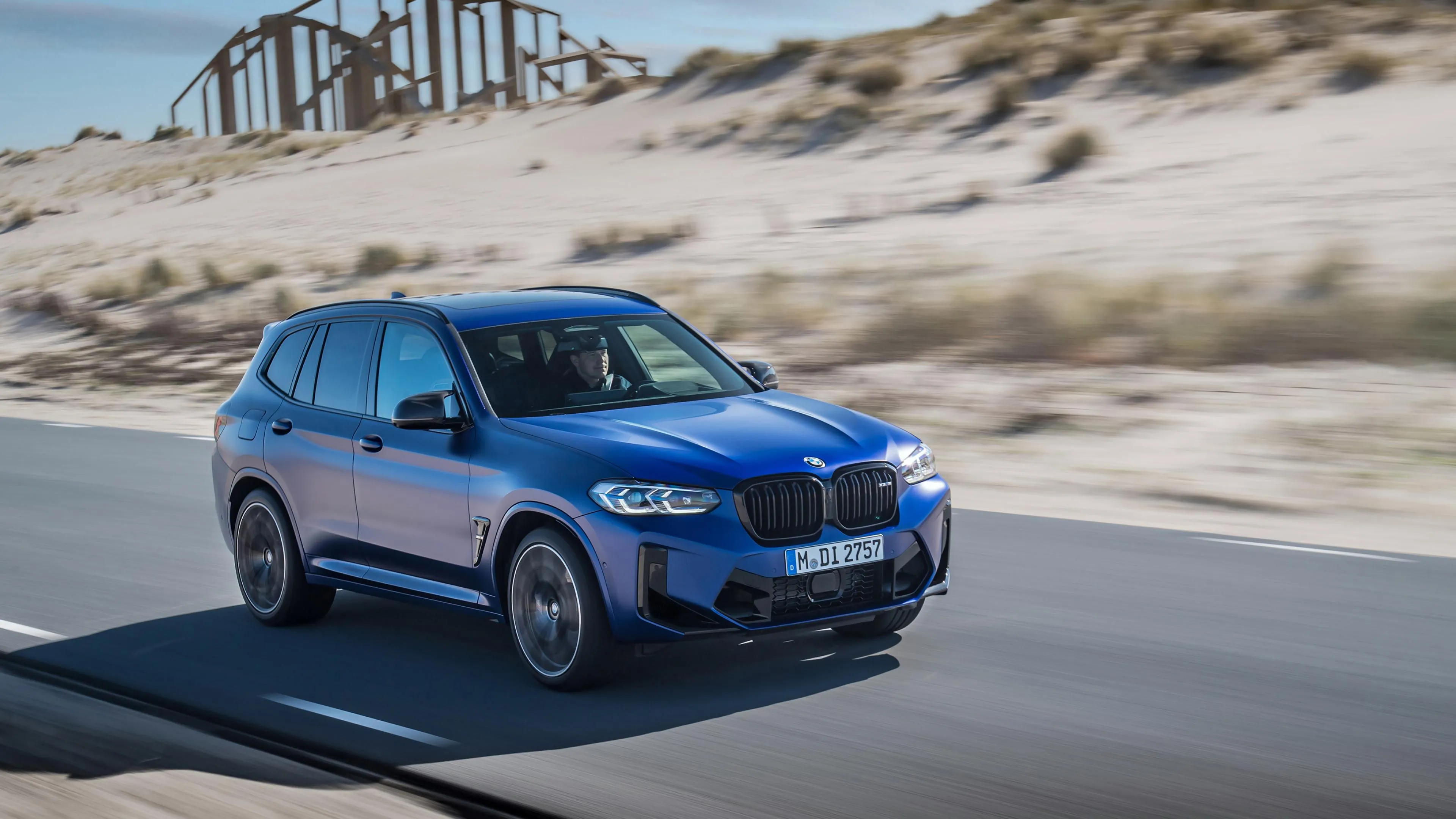 Blue Bmw Driving Fast on Highway with Desert Background