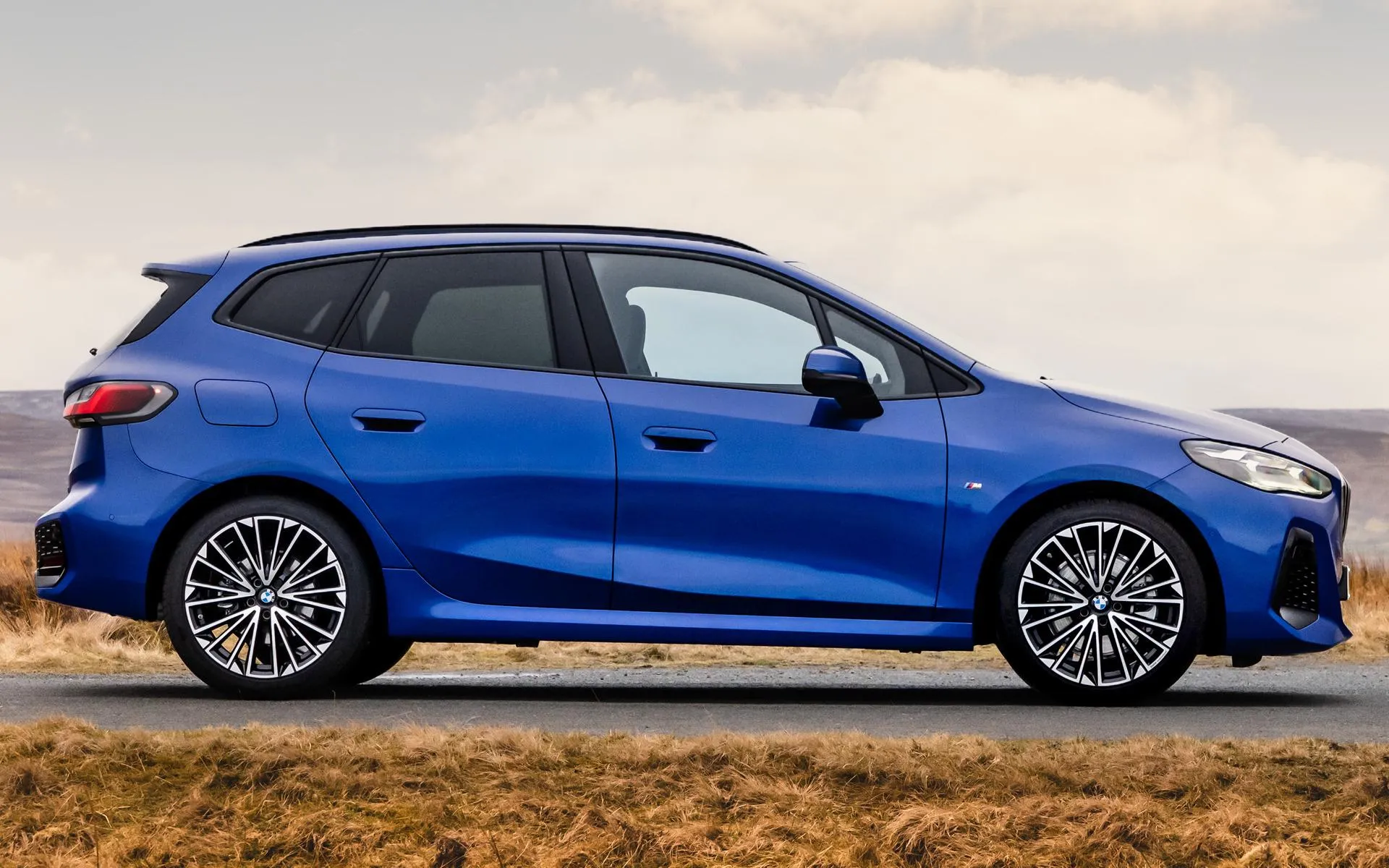 Blue Bmw Hatchback Parked on a Clear Sunny Street Image