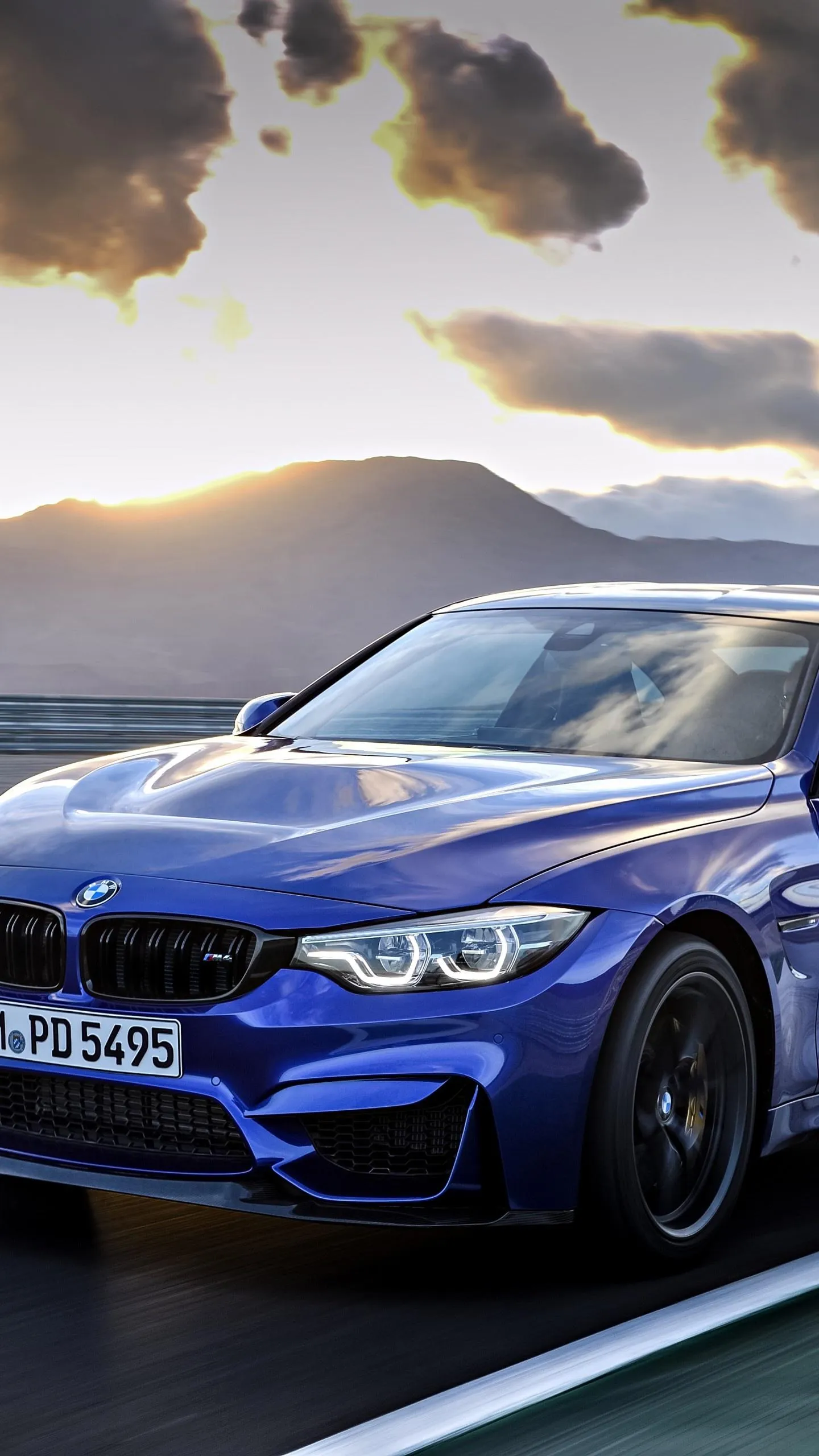 Blue Bmw M Series Driving Under Dramatic Stormy Sky
